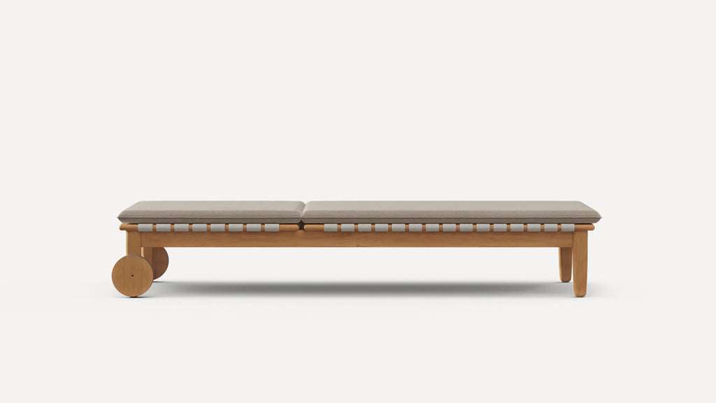 Minimalist wooden bench with two round wheels on one end and cushioned beige seat, modern design.