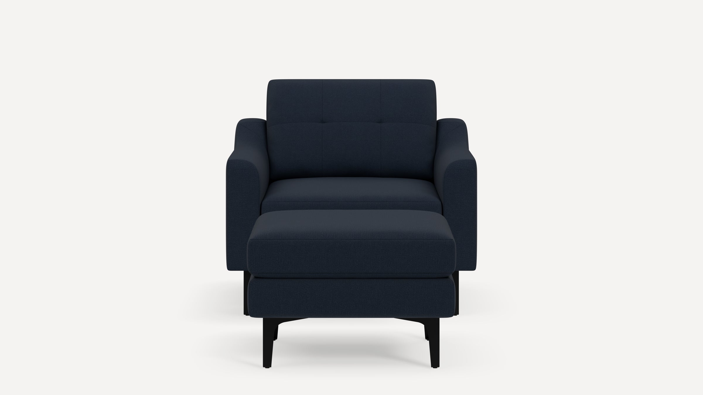 Front view of a modern navy blue upholstered armchair with a matching ottoman and black legs on a white background.