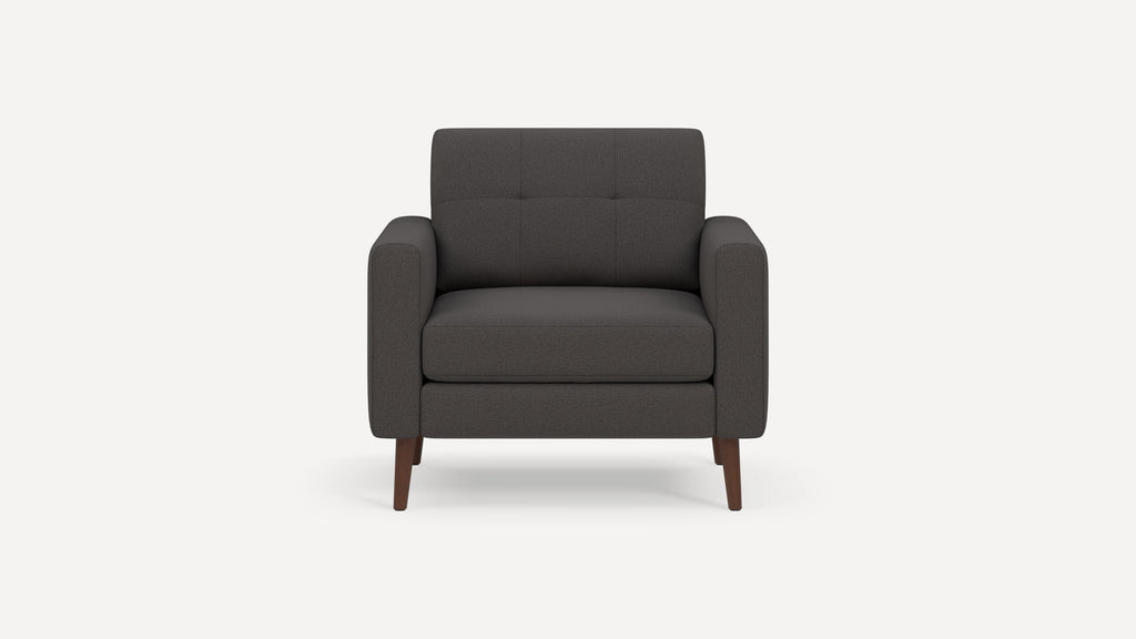 Modern dark gray fabric armchair with tufted backrest and wooden tapered legs, viewed from front.