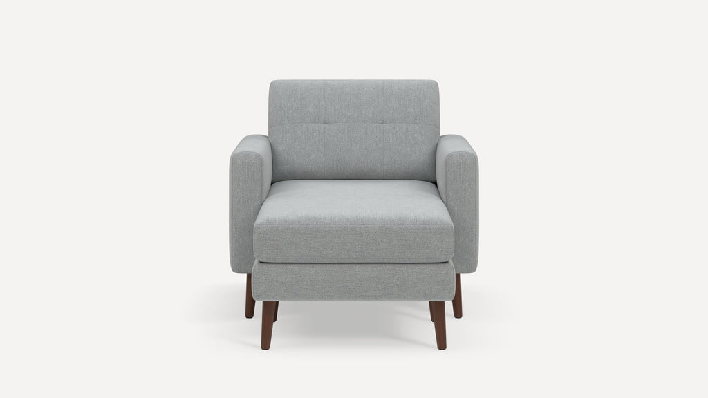 Modern light gray fabric armchair with square arms, tufted back, and dark wooden legs on a white background.