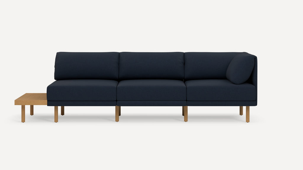 Modern three-seater navy blue sofa with wooden legs and attached side table, featuring clean lines and minimalistic design.