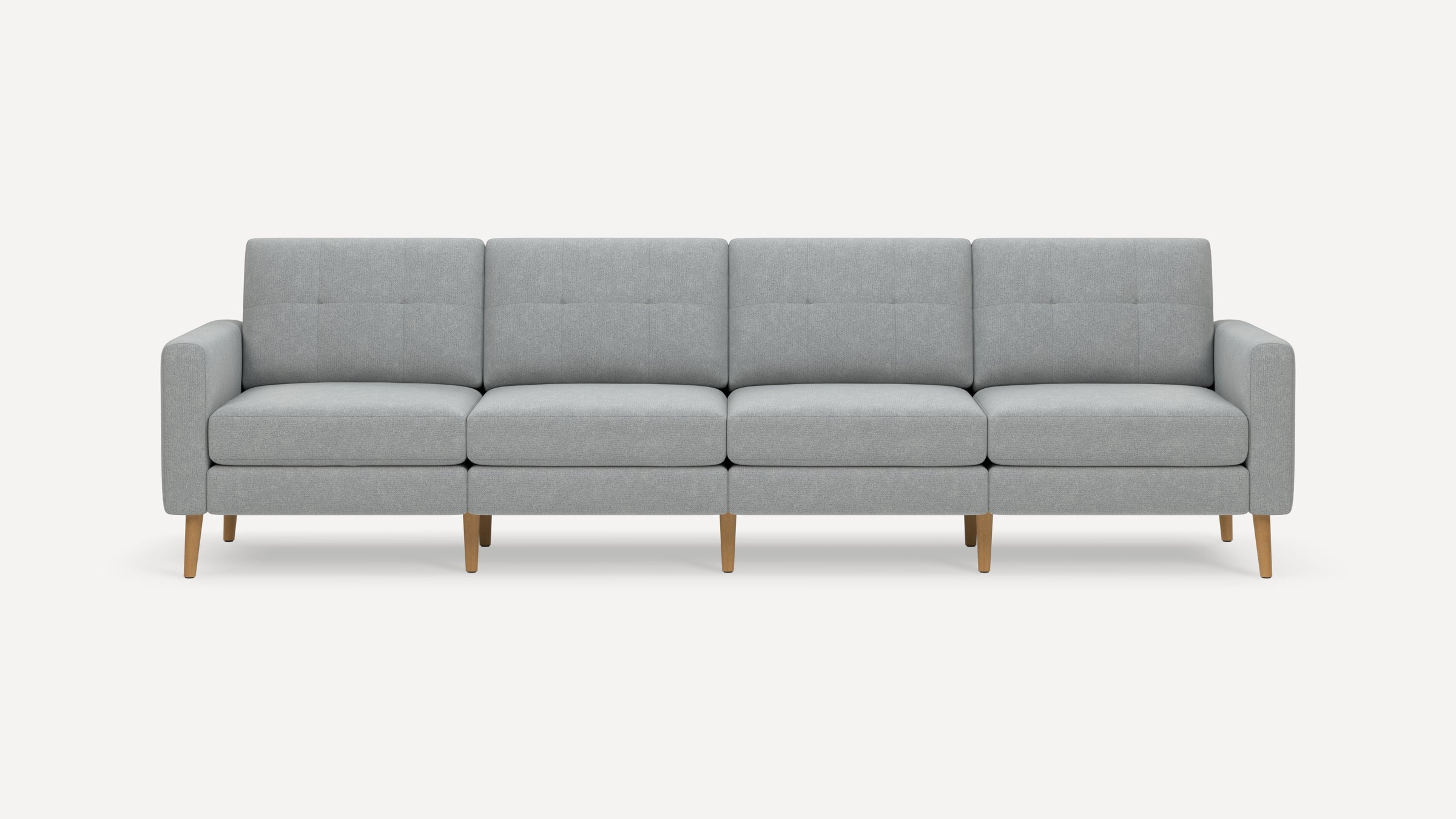 Modern four-seater sofa with light gray fabric upholstery, tufted back cushions, and wooden tapered legs.