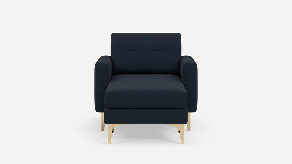 Front view of a modern navy blue upholstered armchair with light wooden legs against a white background.
