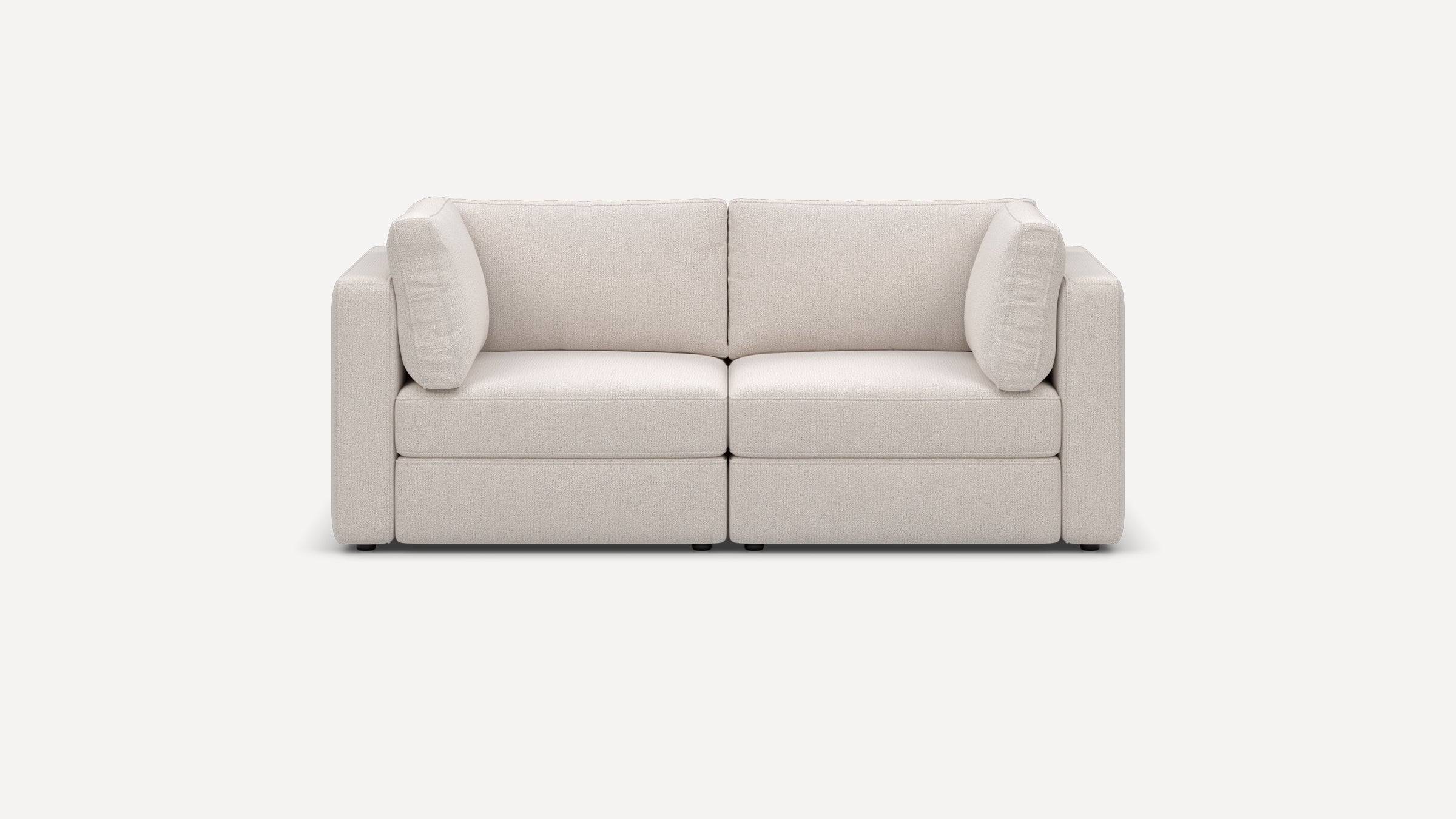 Front view of a modern, minimalist two-seater sofa in soft off-white fabric with thick cushions and block-style armrests.