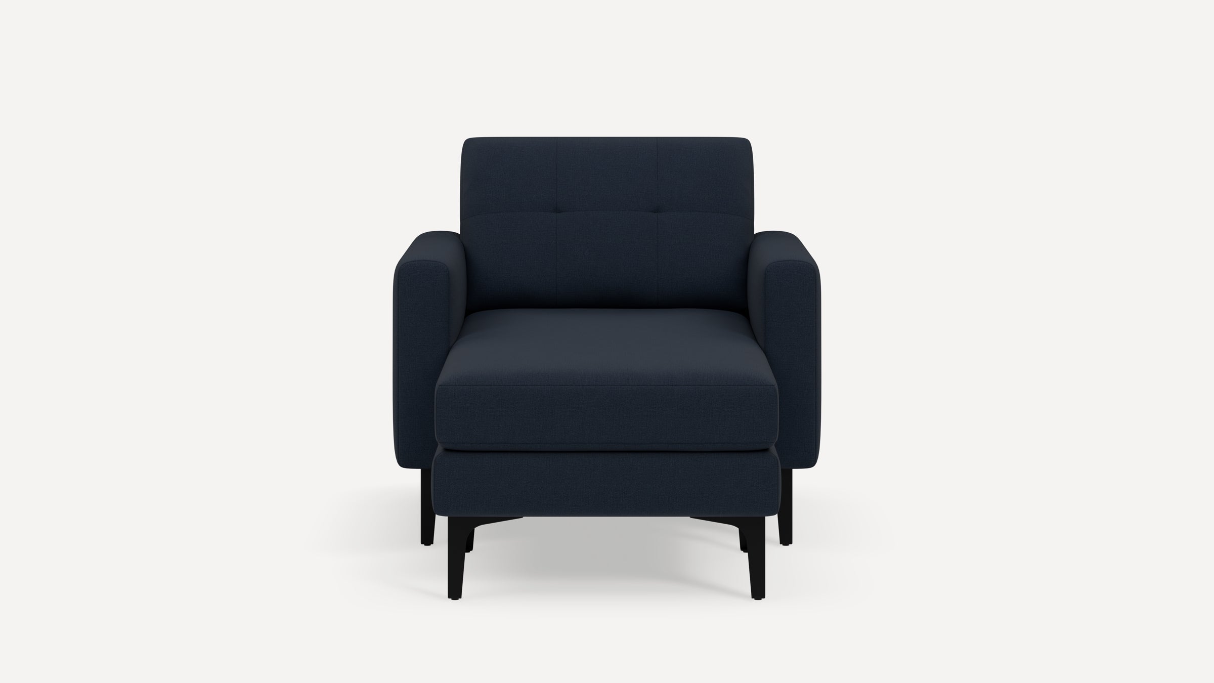 Front view of a modern dark blue upholstered armchair with matching ottoman and black wooden legs on a white background.