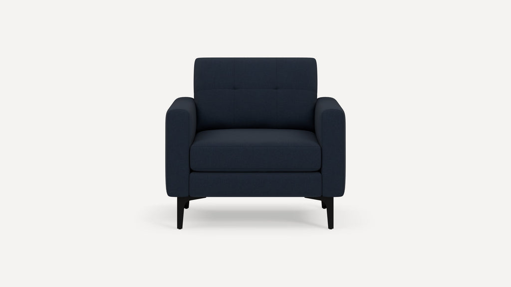 Modern navy blue upholstered armchair with clean lines, tufted backrest, and black angled legs on white background.