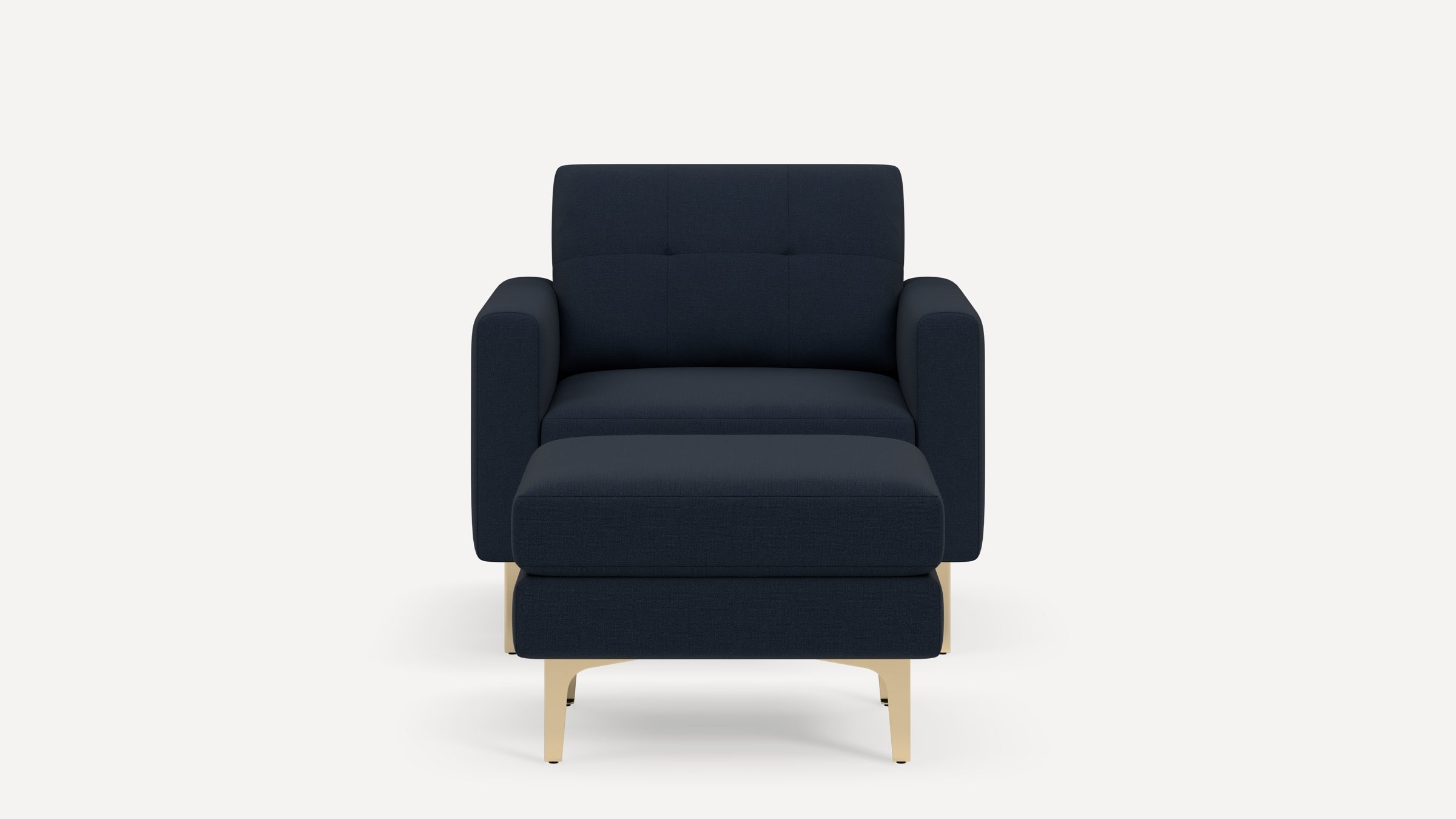 Modern dark blue upholstered armchair with matching ottoman and light wooden legs, shown on white background.