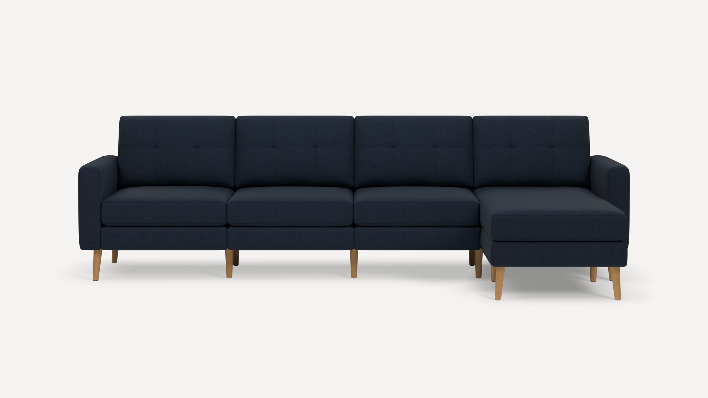 Modern navy blue sectional sofa with tufted back cushions and light wooden legs, featuring a right-side chaise lounge.