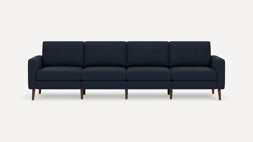 Four-seater navy blue modern sofa with tufted cushions and wooden legs, featuring clean lines and armrests on each side.