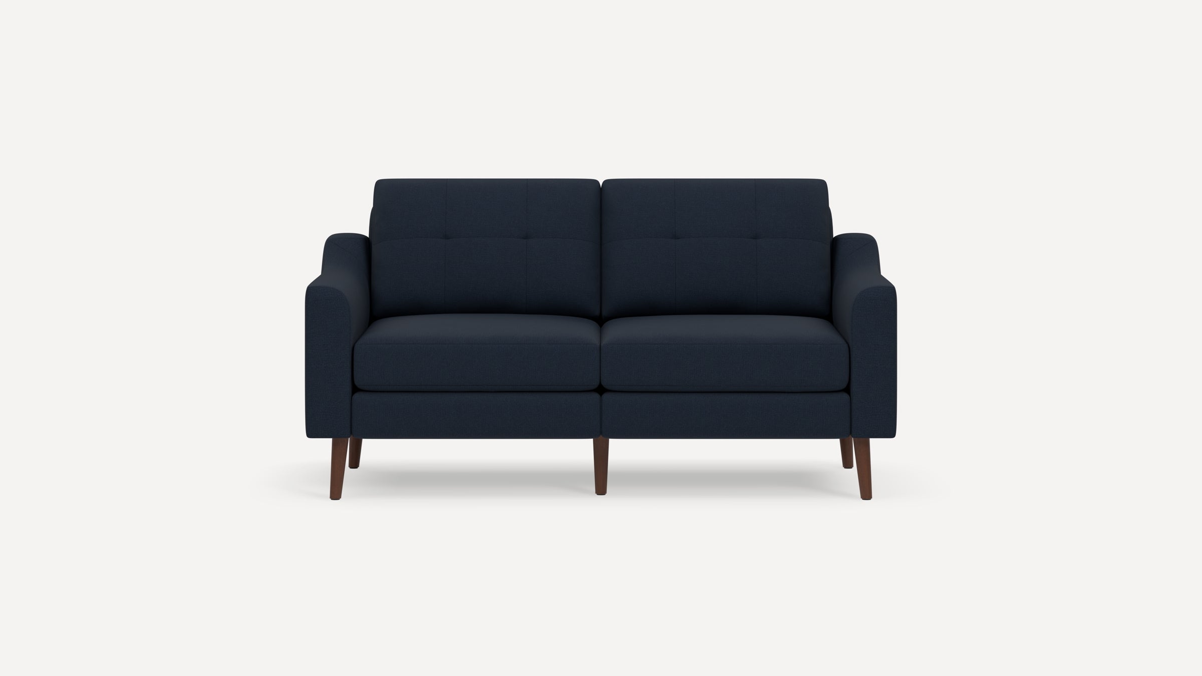 Mid-century modern navy blue two-seater sofa with tufted cushions and dark wooden tapered legs on plain white background.