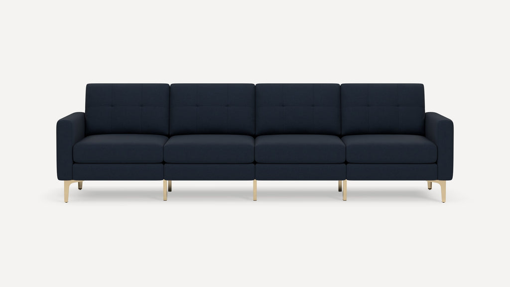 Modern four-seater navy blue fabric sofa with tufted back cushions and sleek light wooden legs on a white background.
