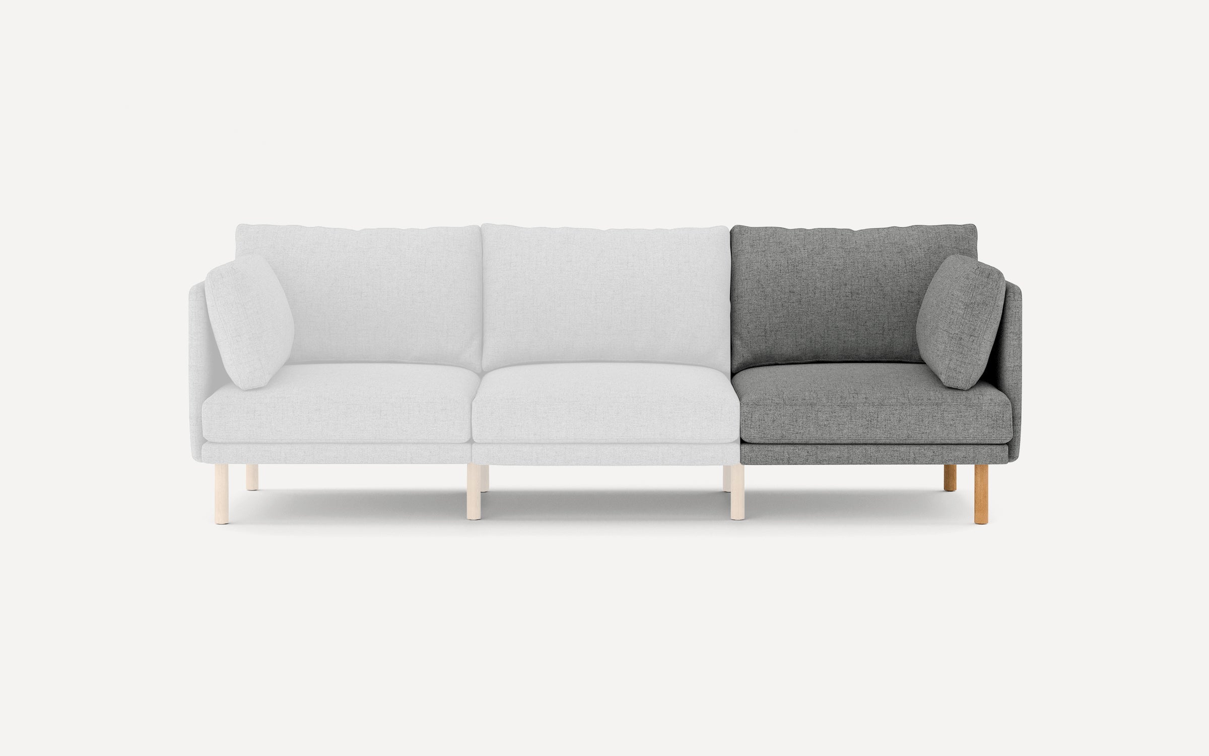 Modern three-seater sofa with light gray upholstery on two seats and dark gray upholstery on one end seat, wooden legs, and matching cushions.