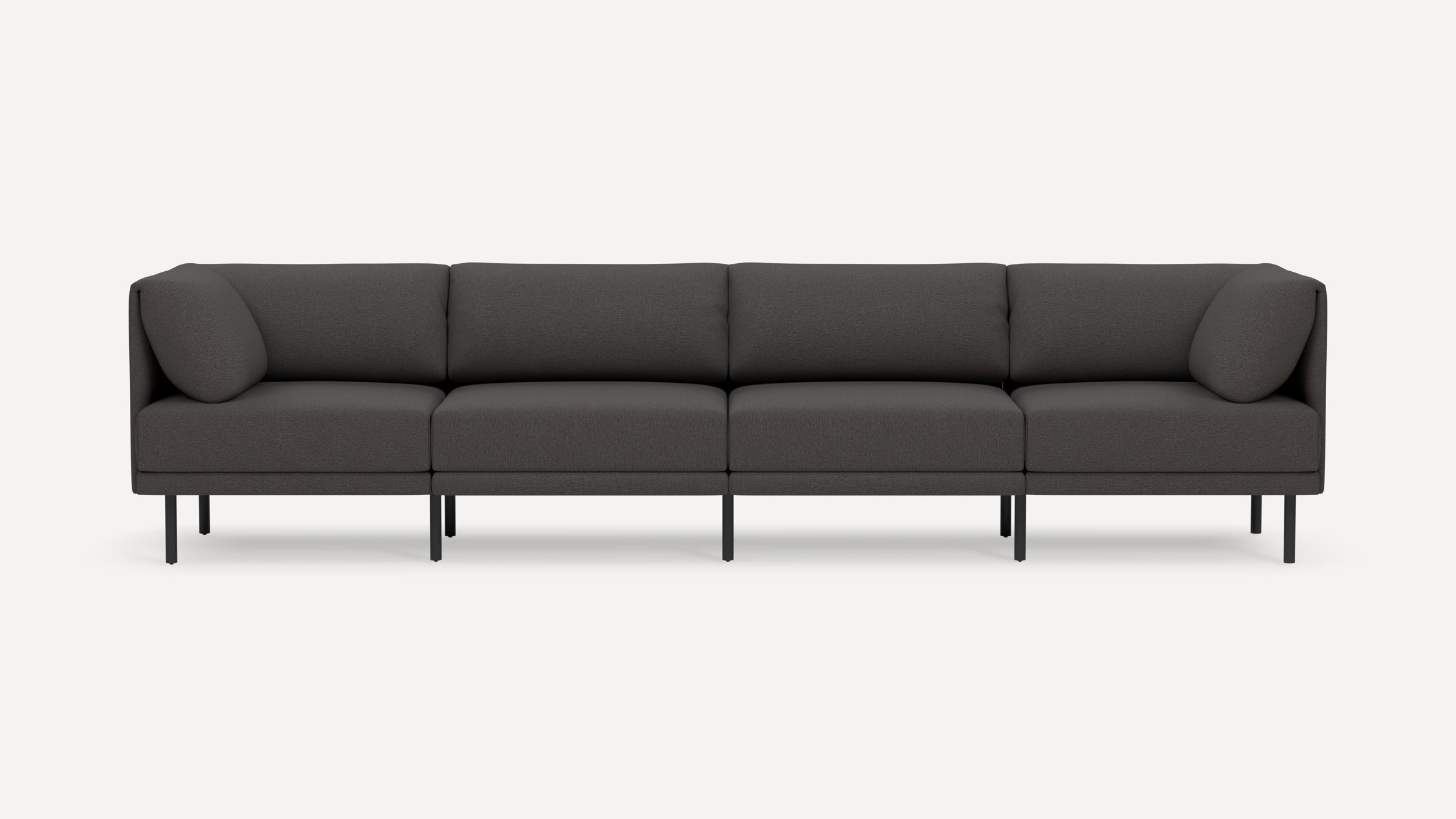Modern dark gray four-seater sofa with clean lines, upholstered cushions, rounded armrests, and slim black legs on white background.