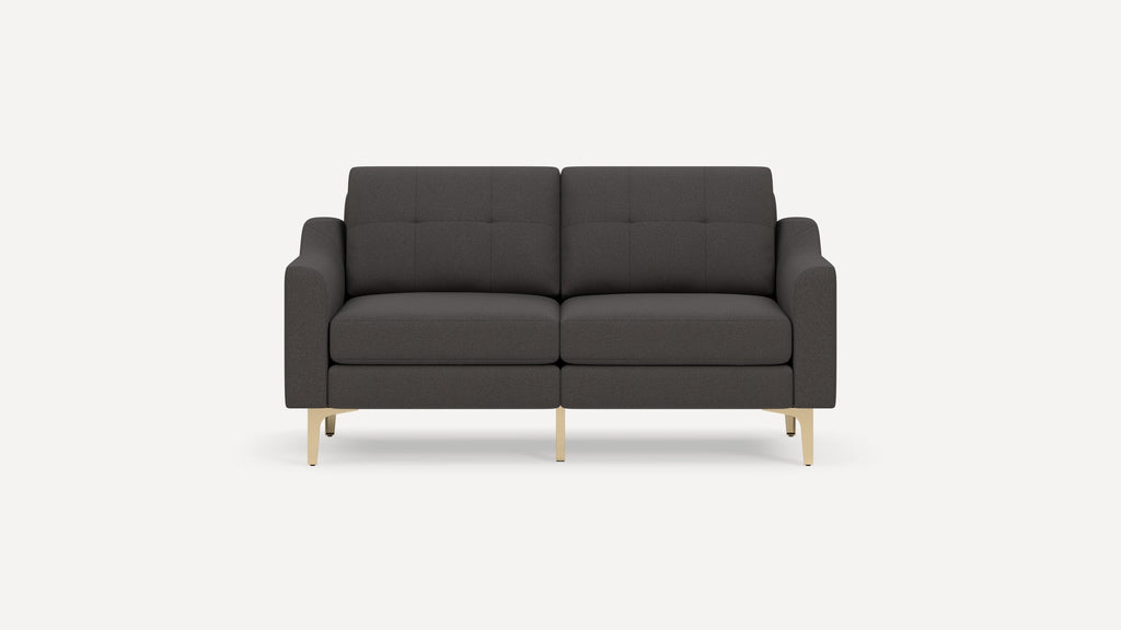Dark gray two-seater sofa with tufted backrest, cushioned seats, straight arms, and light wood legs on white background.