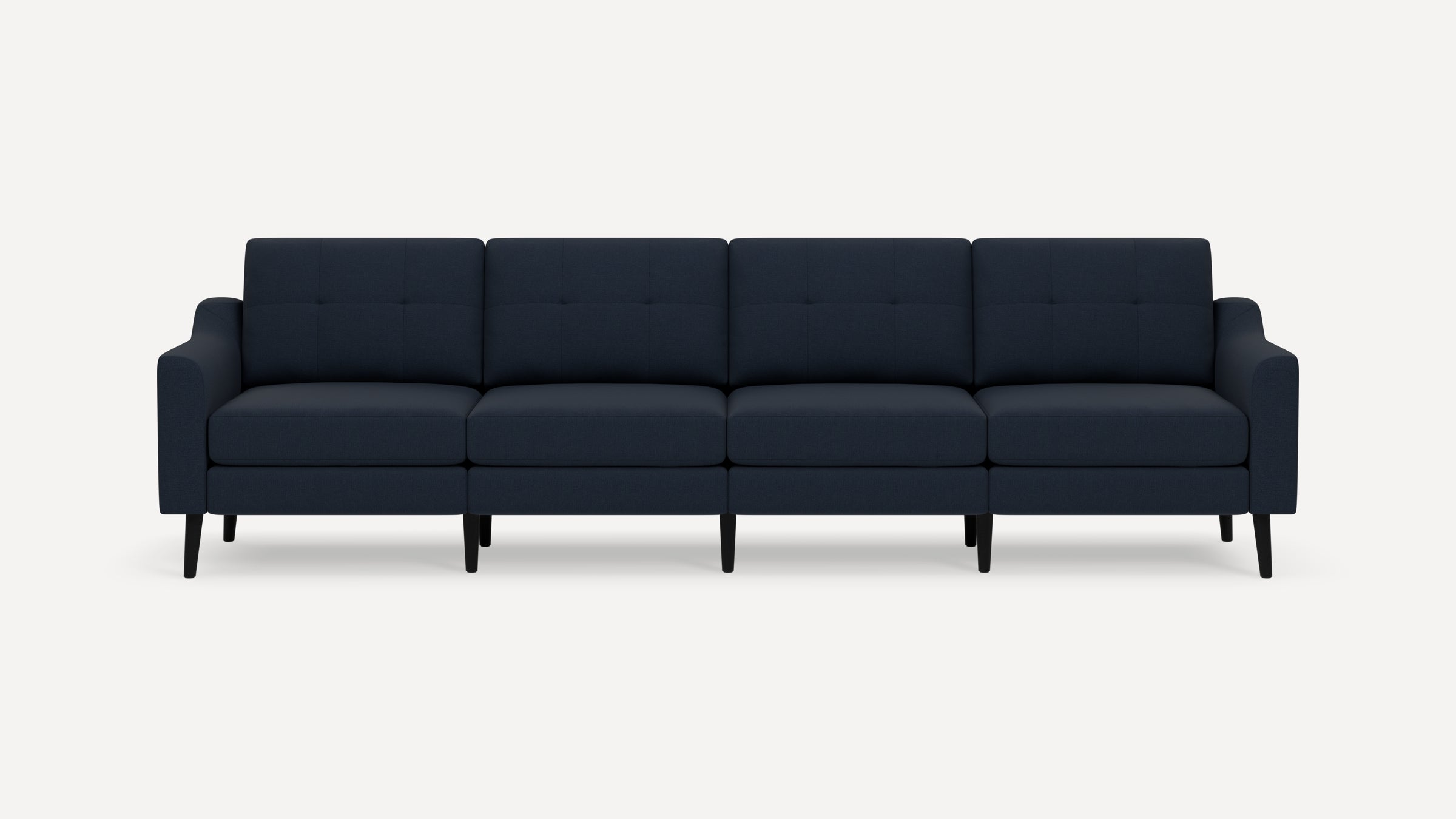 Modern navy blue four-seater sofa with tufted back cushions, slim armrests, and black tapered legs on a white background.