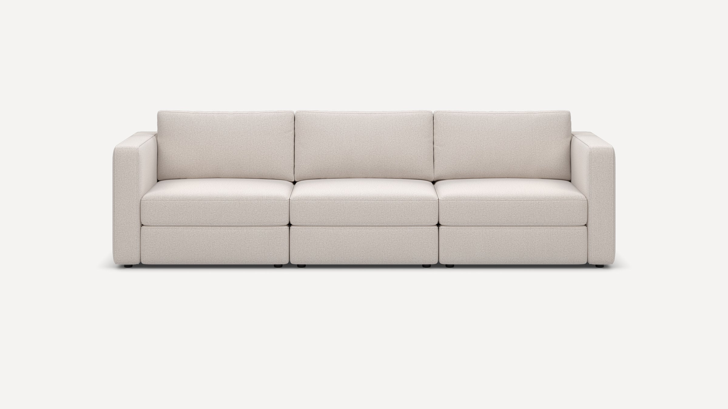 Modern three-seater sofa with wide armrests, plush cushions, and light beige fabric upholstery on a minimalist background.