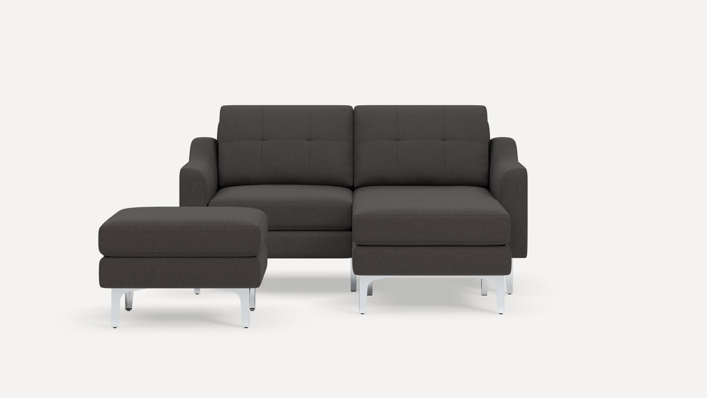 Dark gray modern sectional sofa with tufted cushions and matching ottoman, both featuring sleek silver metal legs.