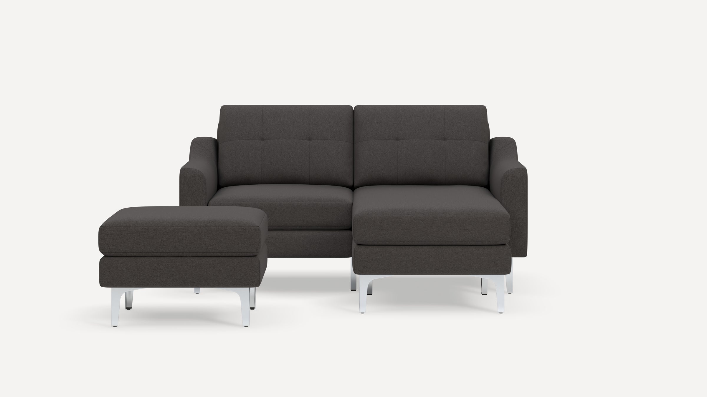 Dark gray modern sectional sofa with tufted cushions and matching ottoman, both featuring sleek silver metal legs.