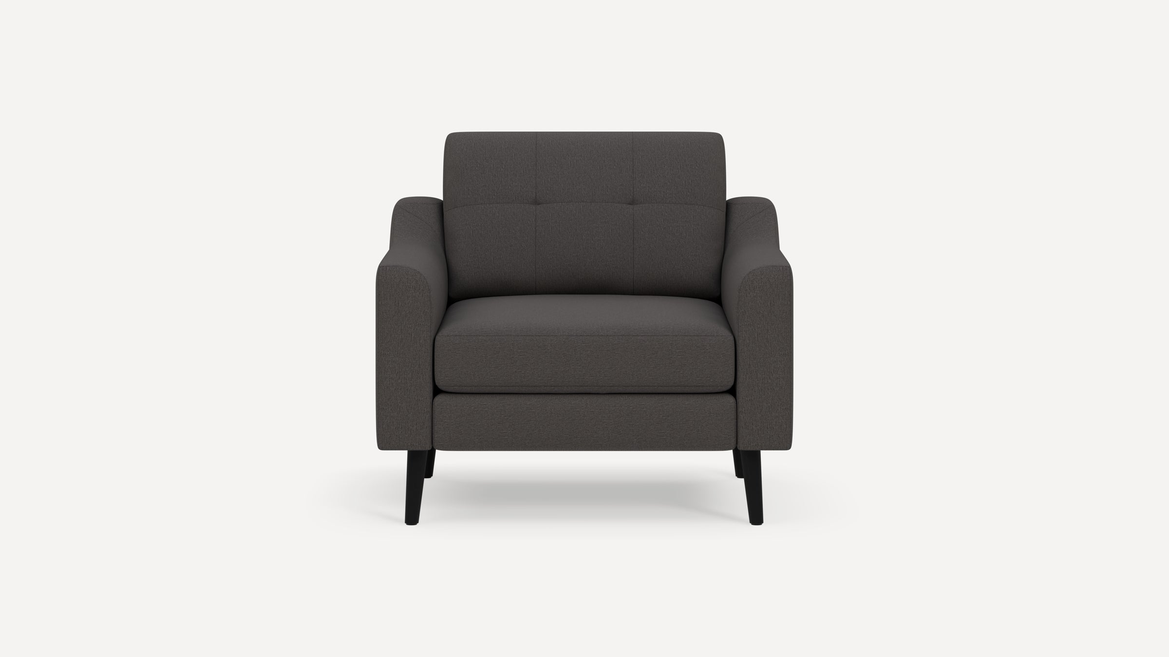 Modern dark gray fabric armchair with padded seat and backrest, featuring tufted detailing and black tapered legs.