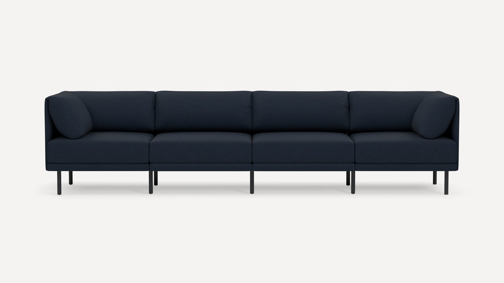 Modern navy blue four-seat sofa with clean lines, slim black legs, and plush back and side cushions on a white background.