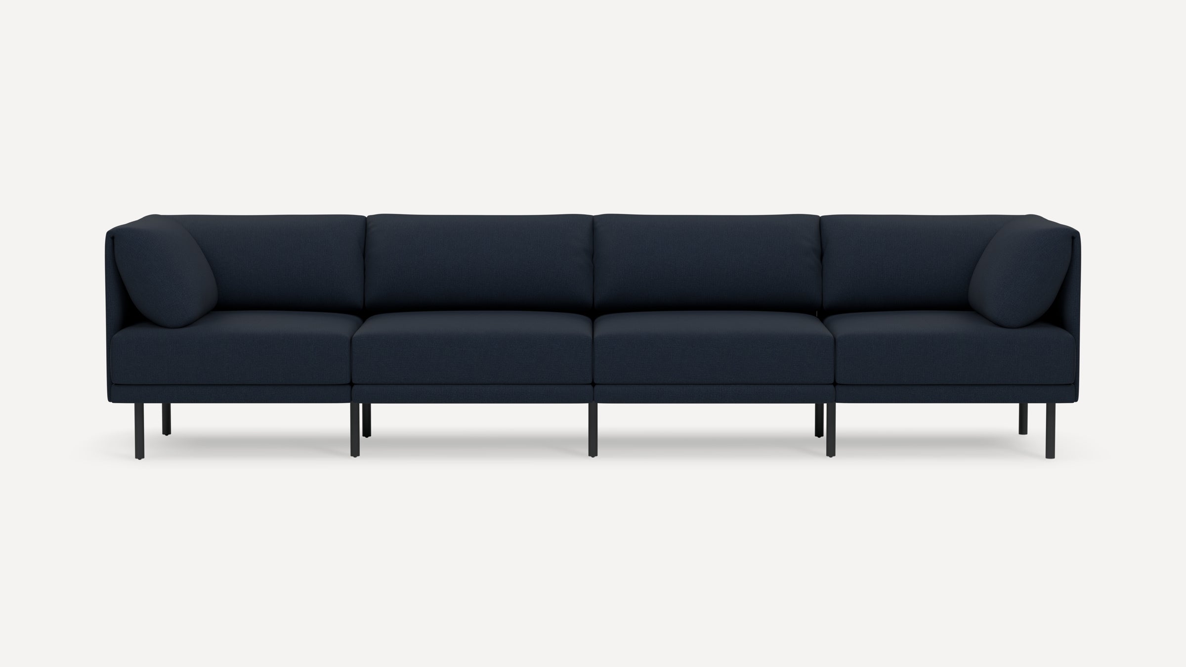 Modern navy blue four-seat sofa with clean lines, slim black legs, and plush back and side cushions on a white background.