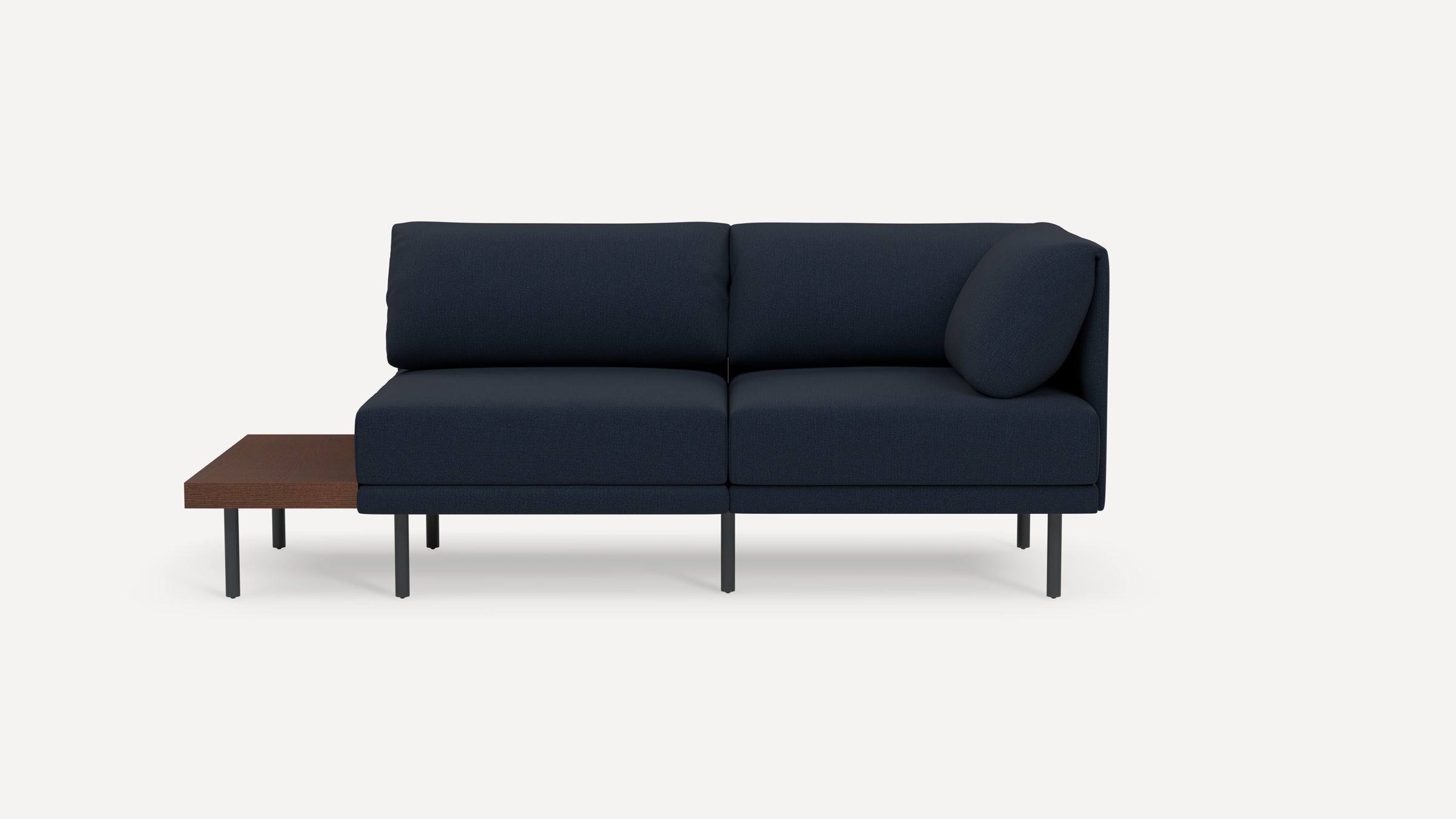 Modern navy blue sectional sofa with black legs and an attached low wooden side table on the left side.