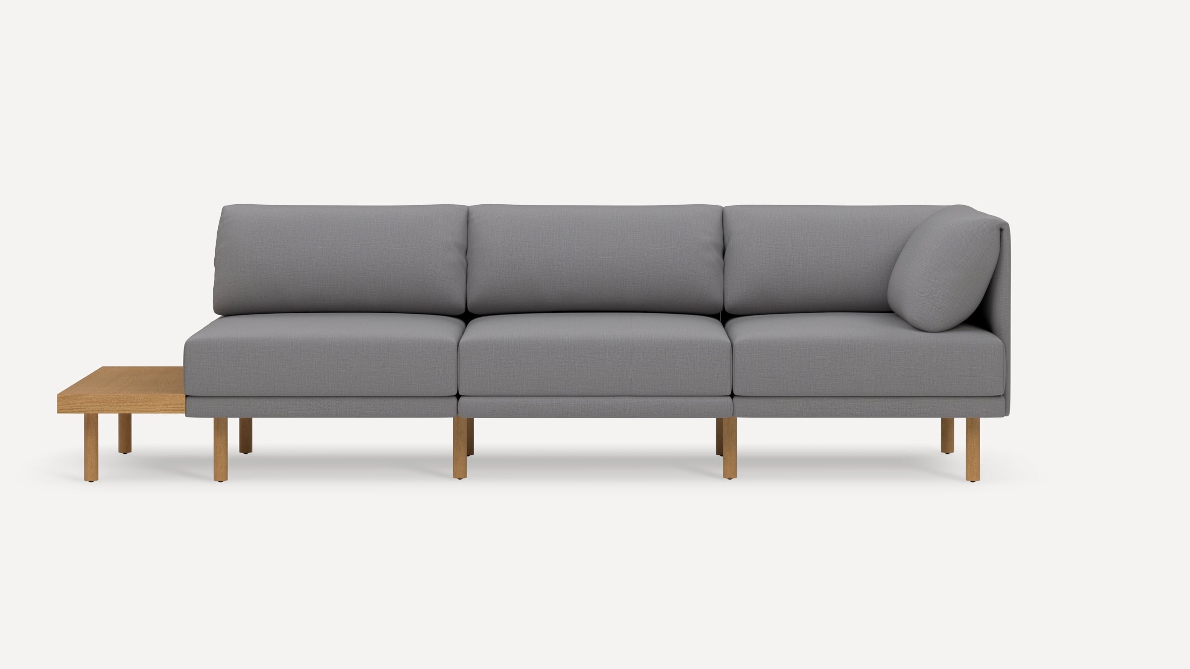 Modern gray fabric three-seater sofa with light wooden legs and an attached side table on the left end.
