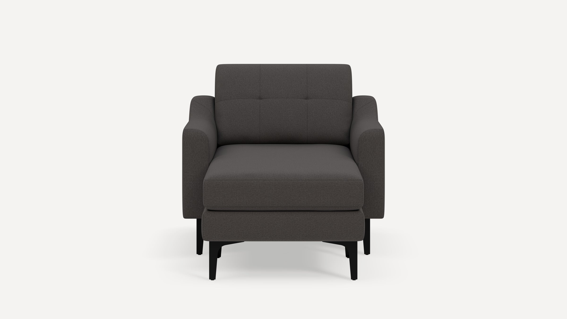 Modern dark gray upholstered armchair with matching ottoman, square tufted back, and black wooden legs on white background.