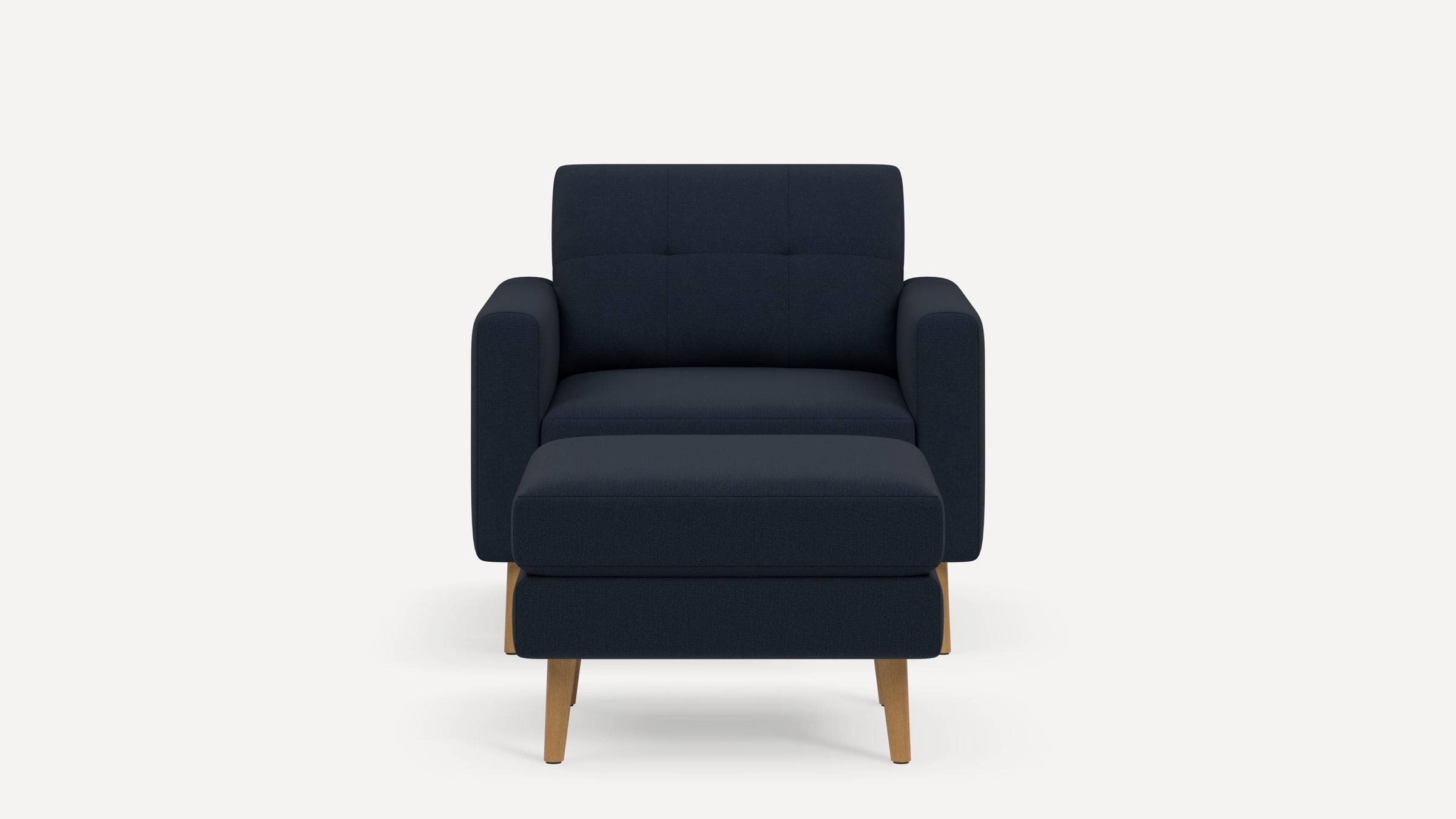 Front view of a modern navy blue armchair with matching ottoman, featuring wooden legs and cushioned armrests.