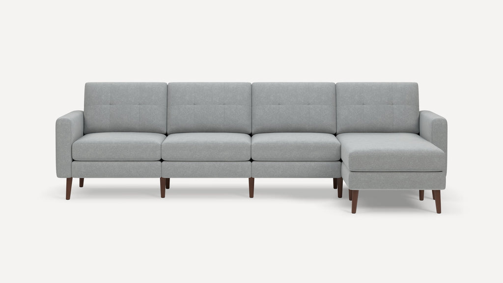 Light grey fabric sectional sofa with wooden legs, four seats, and a right-side chaise lounge.