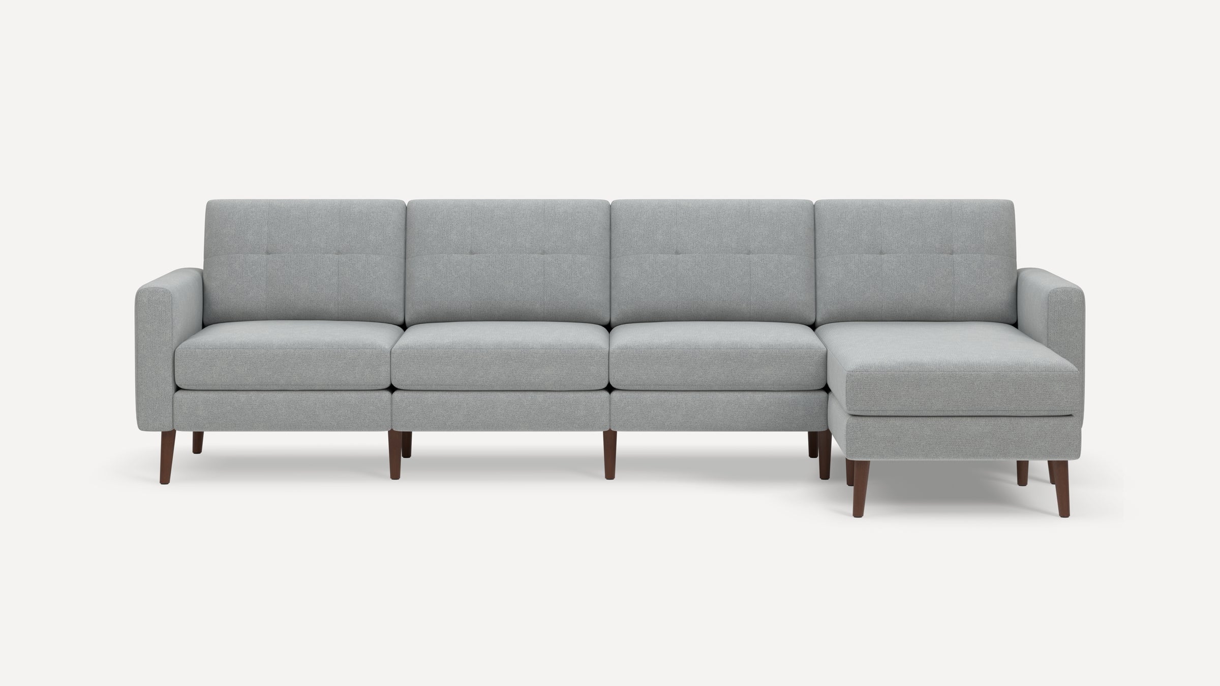Light grey fabric sectional sofa with wooden legs, four seats, and a right-side chaise lounge.