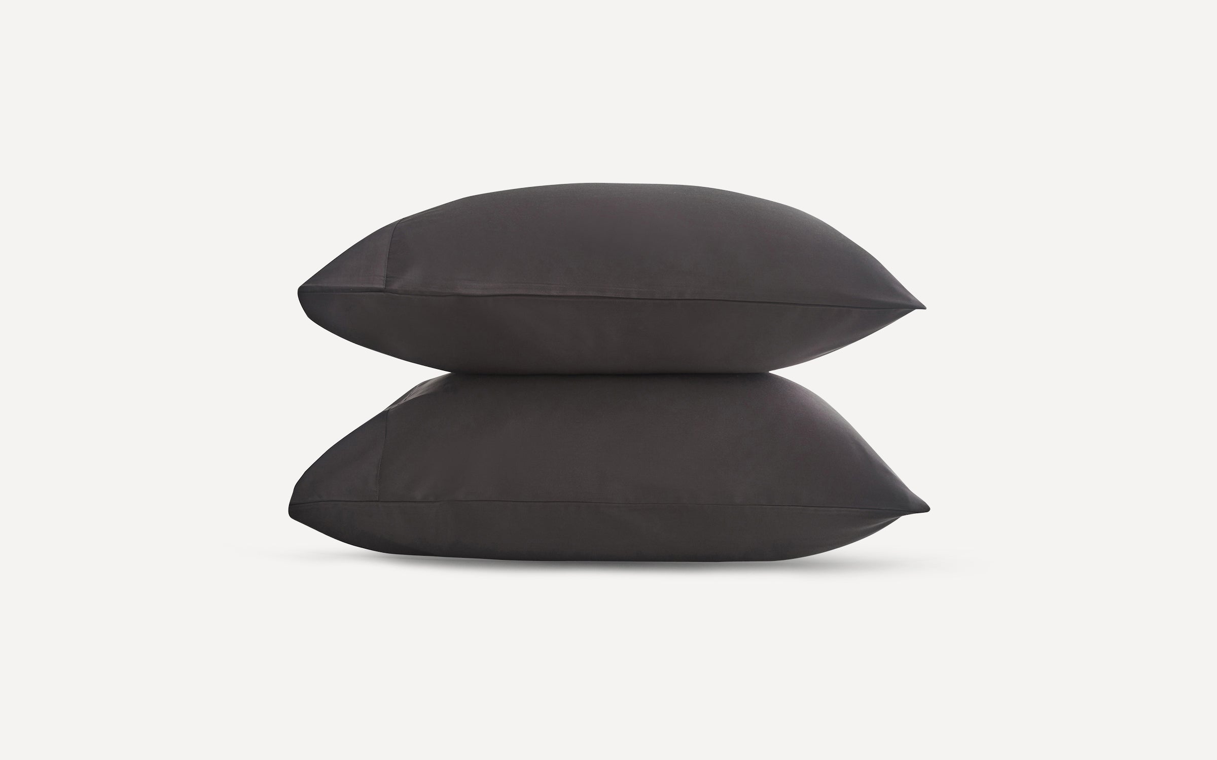 Two dark gray rectangular pillows stacked on a plain white background, showcasing smooth fabric texture and clean edges.