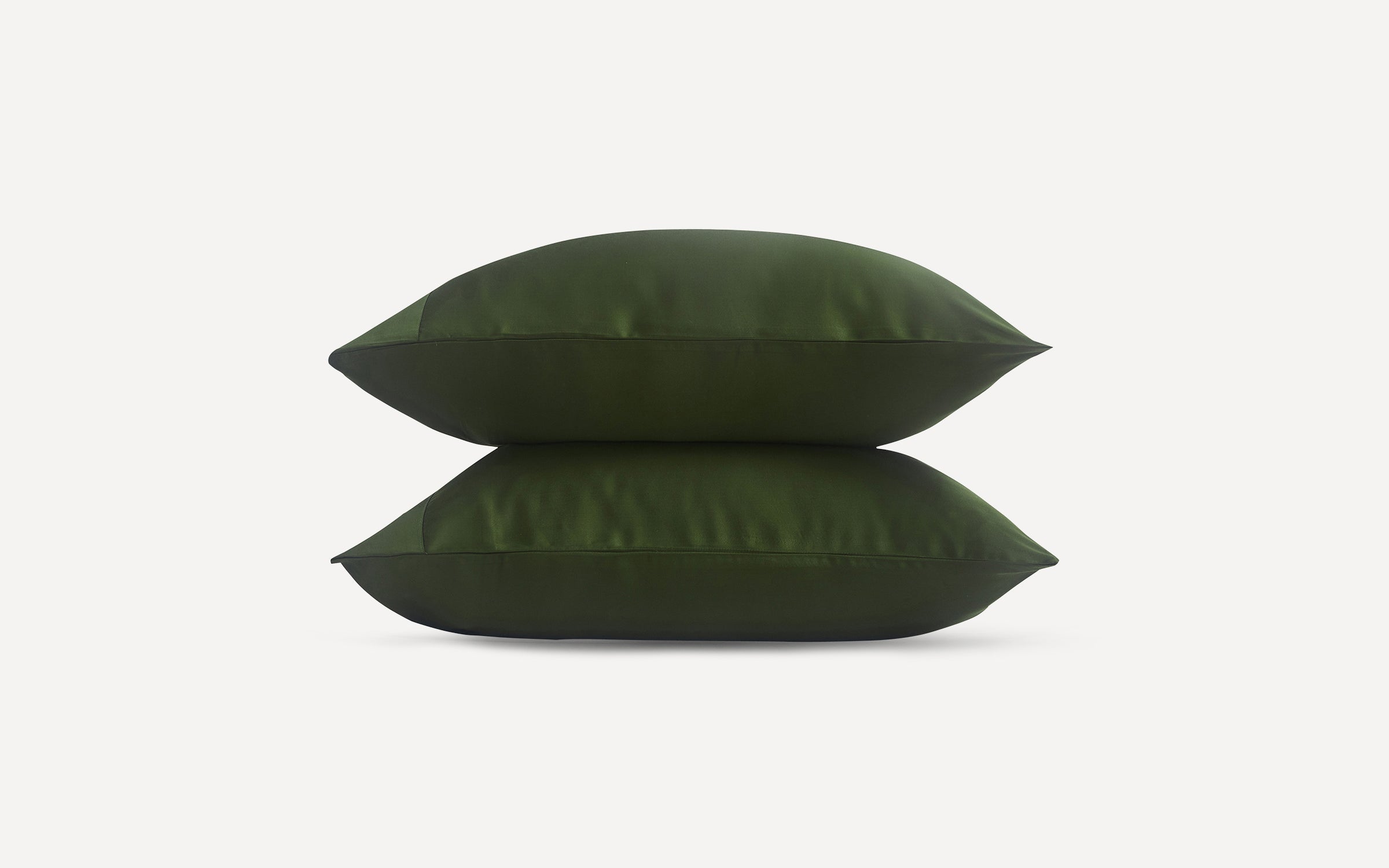Two dark green pillows stacked horizontally on a plain white background.