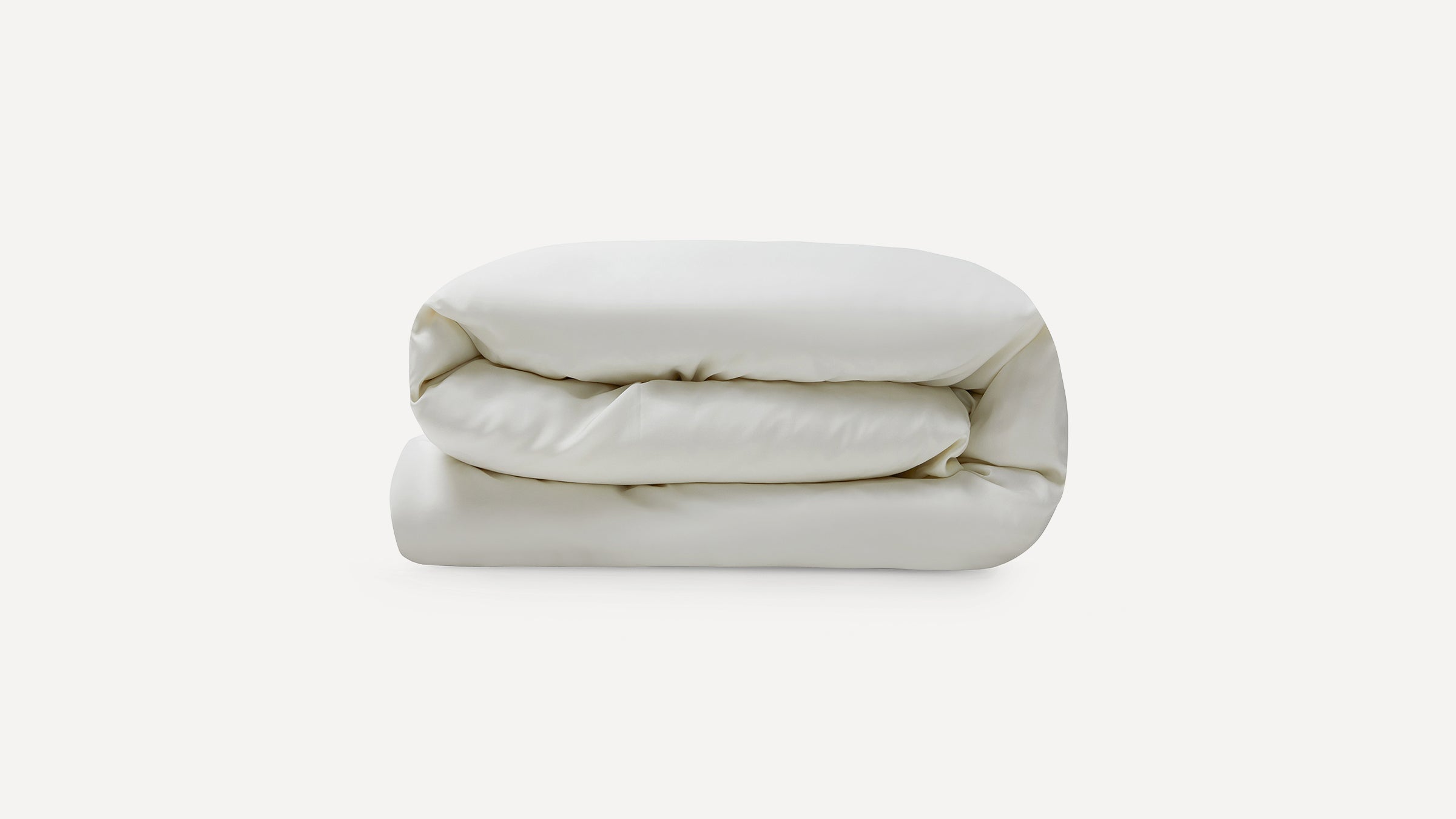 Soft, neatly folded cream-colored duvet or comforter, displayed against a plain white background.