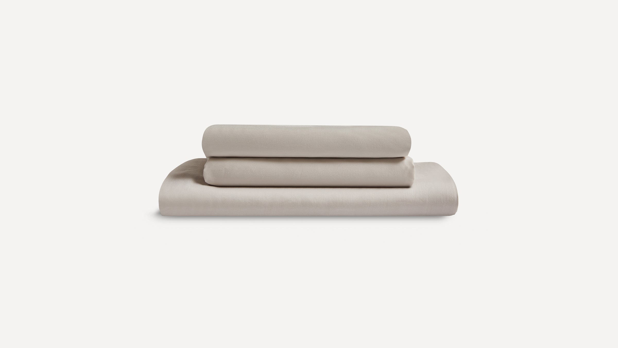 Stack of three neatly folded beige bed sheets on a plain white background.