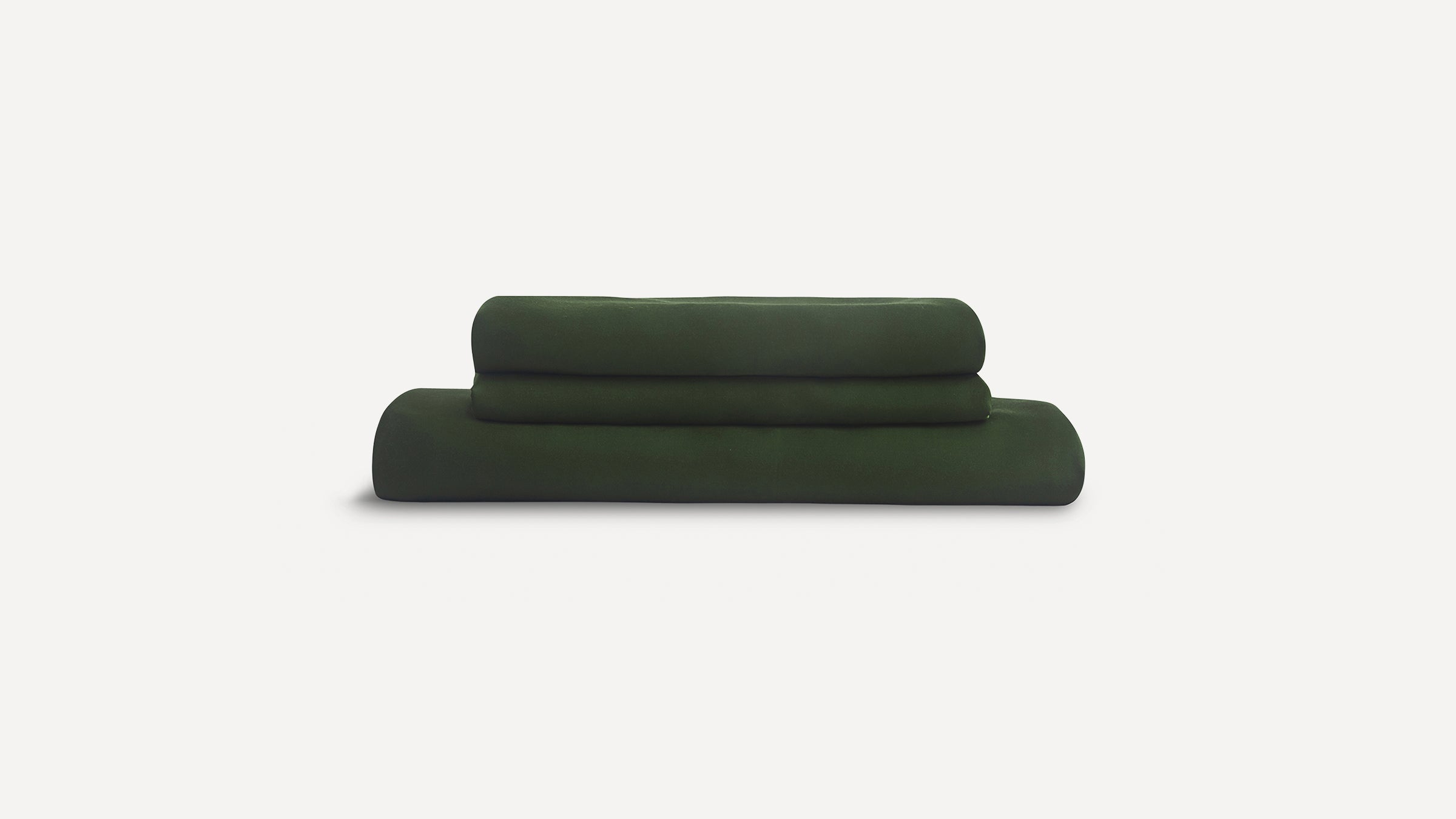 Folded dark green bed sheets stacked neatly against a plain white background.