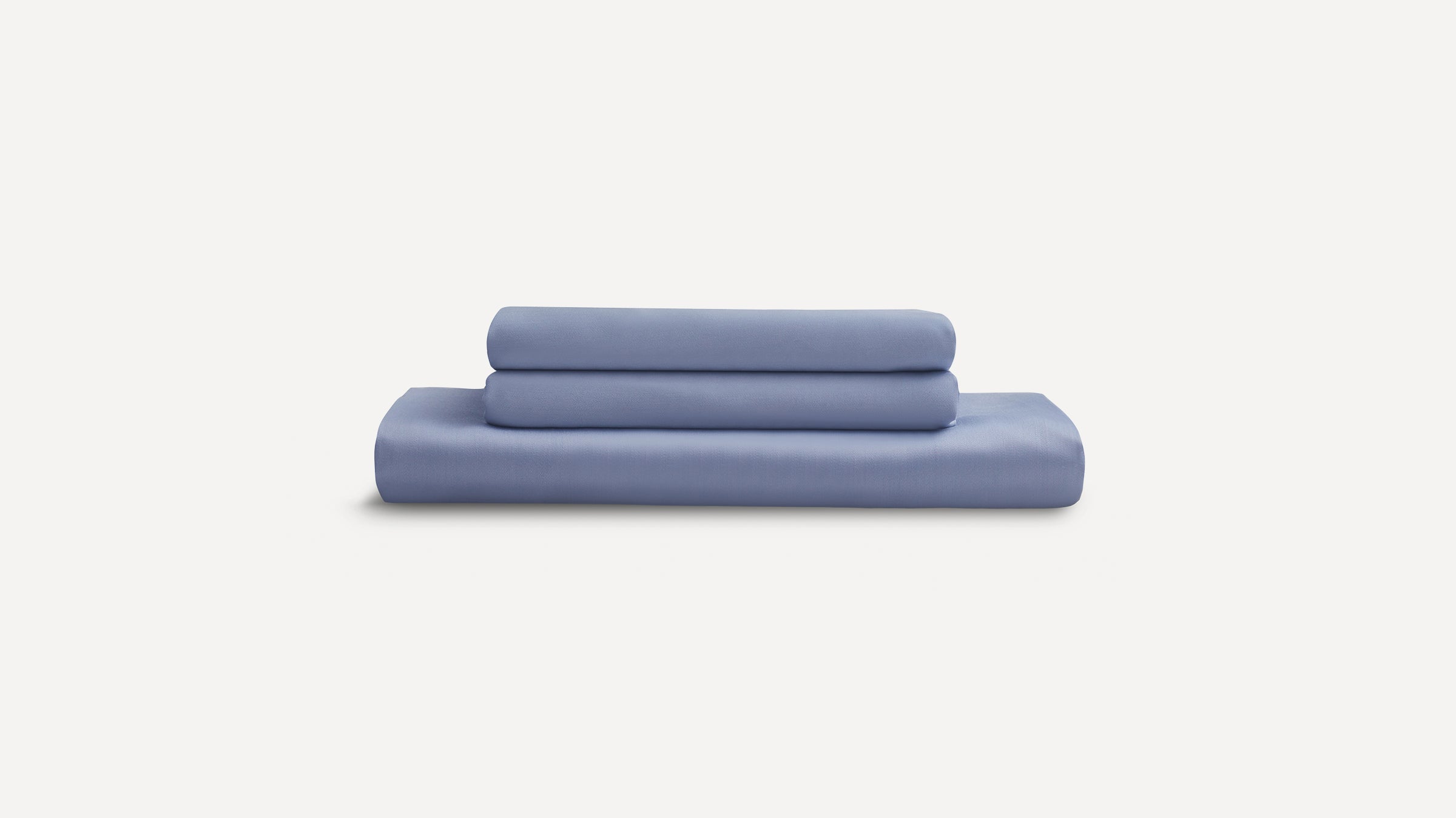 Stack of three neatly folded light blue bedsheets against a white background.