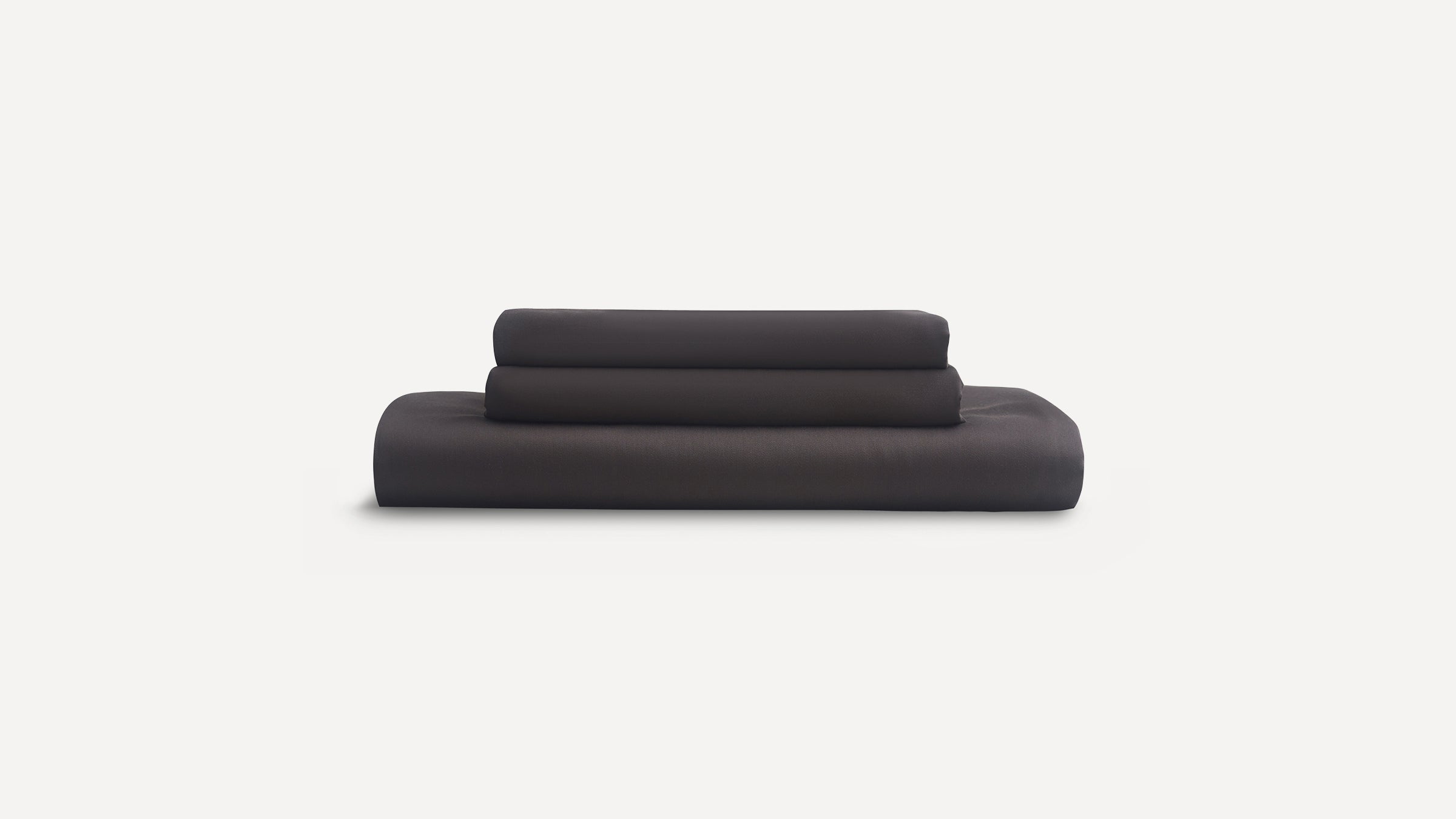 Stack of three neatly folded dark gray bed sheets displayed against a plain white background.