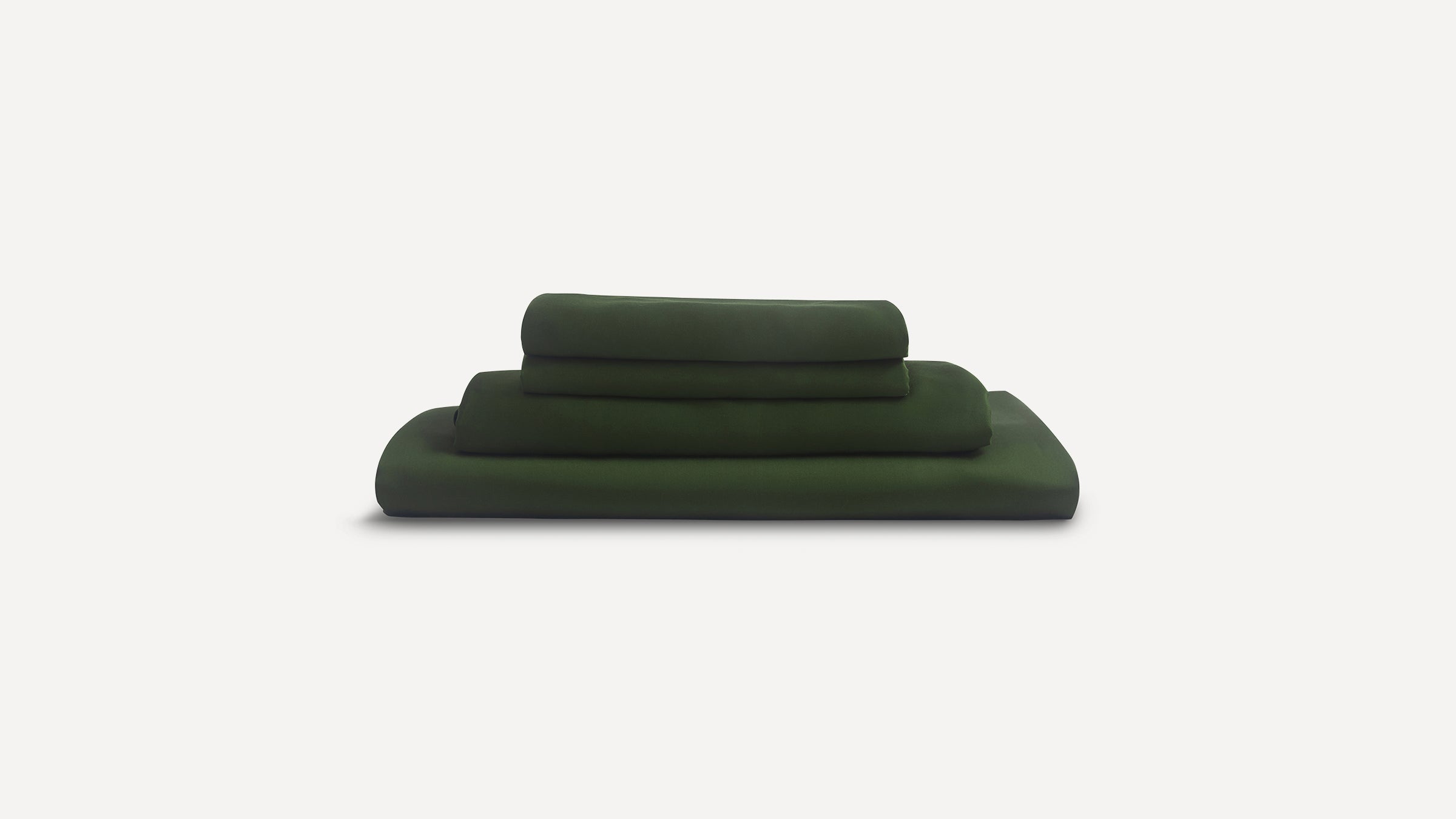 Stack of folded dark green bed sheets neatly arranged against a plain white background.