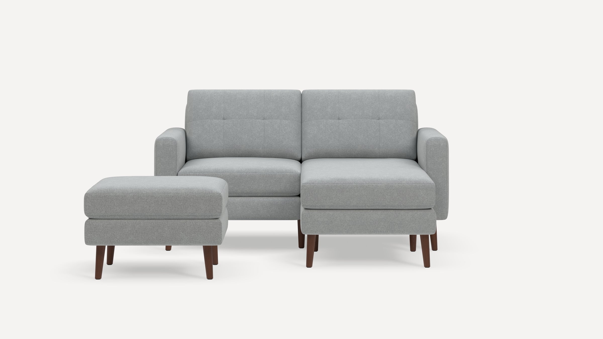 Light grey fabric loveseat with matching ottoman, tufted back cushions, rounded arms, and wooden legs on a white background.