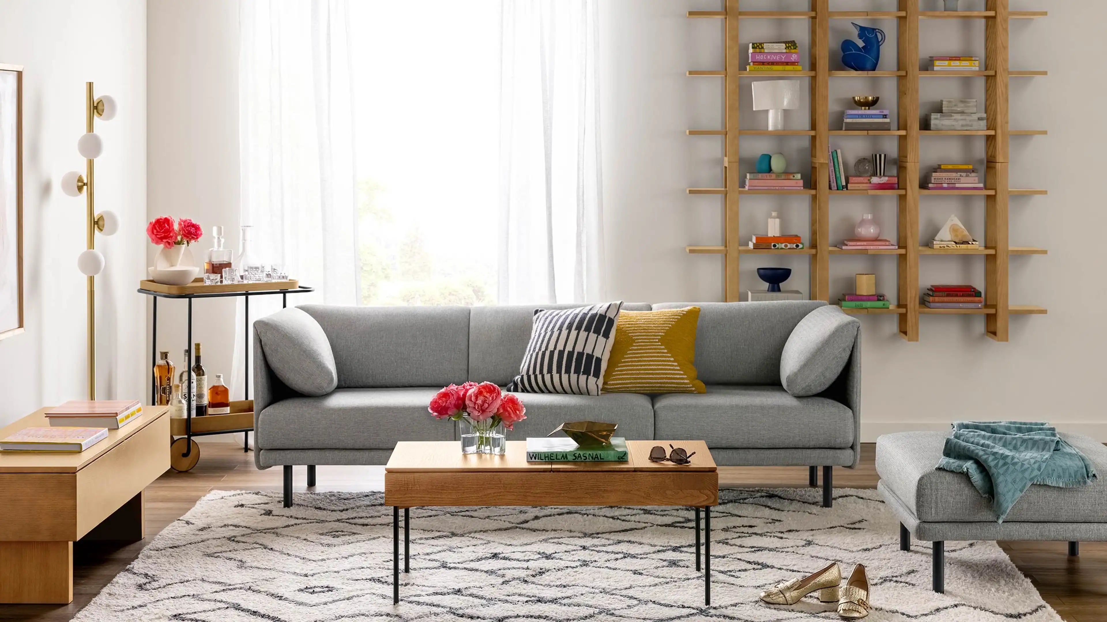 modern living room with gray sofa, wooden coffee table, and wooden shelves