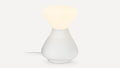 White modern table lamp with a rounded base and soft glowing top, connected by a fabric-covered cord.