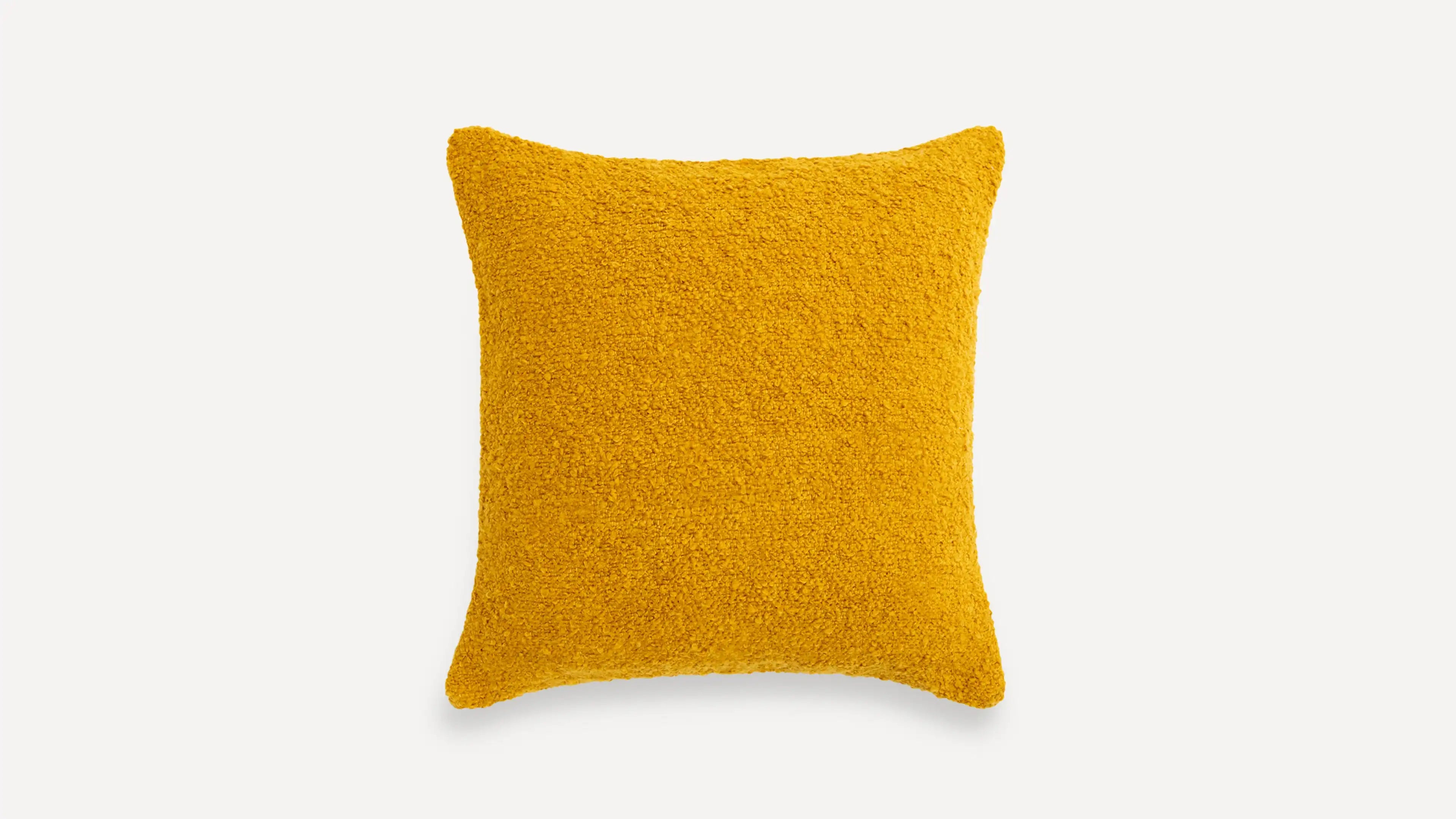 a yellow pillow on a white background