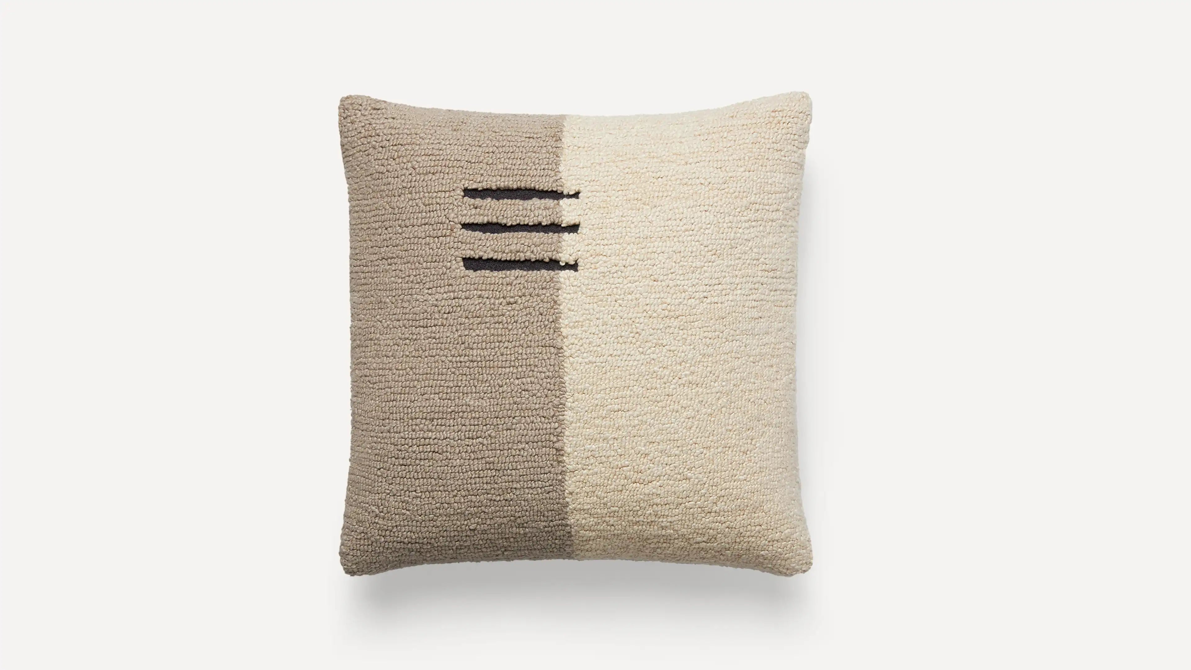 a beige pillow with black and white stripes