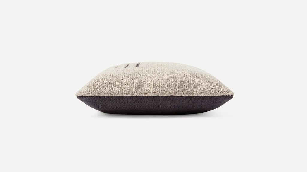 a beige and black cushion with a black pillow on top