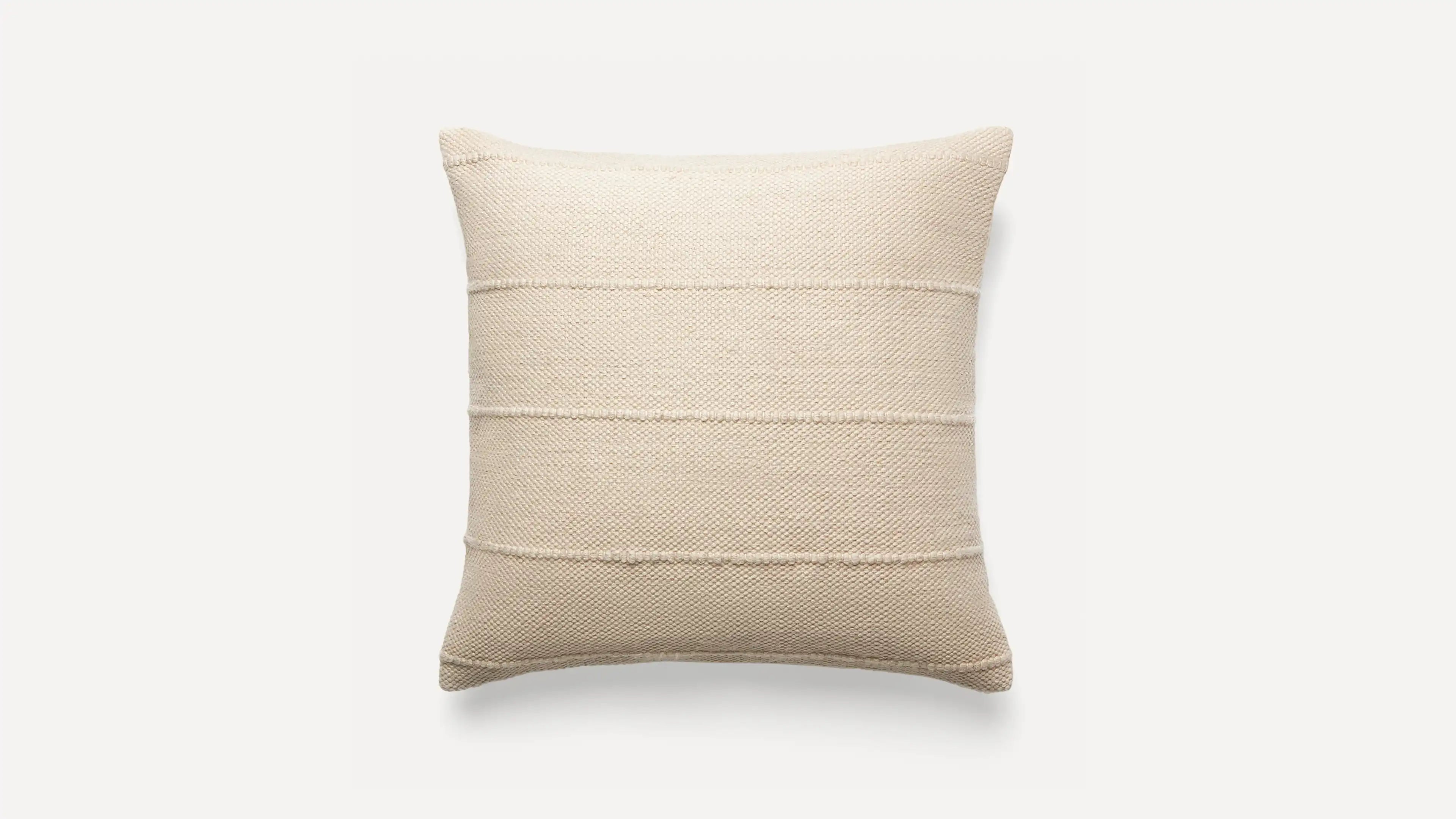 a beige pillow with a striped design on the front