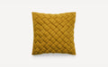 a mustard yellow cushion with braiding on the front