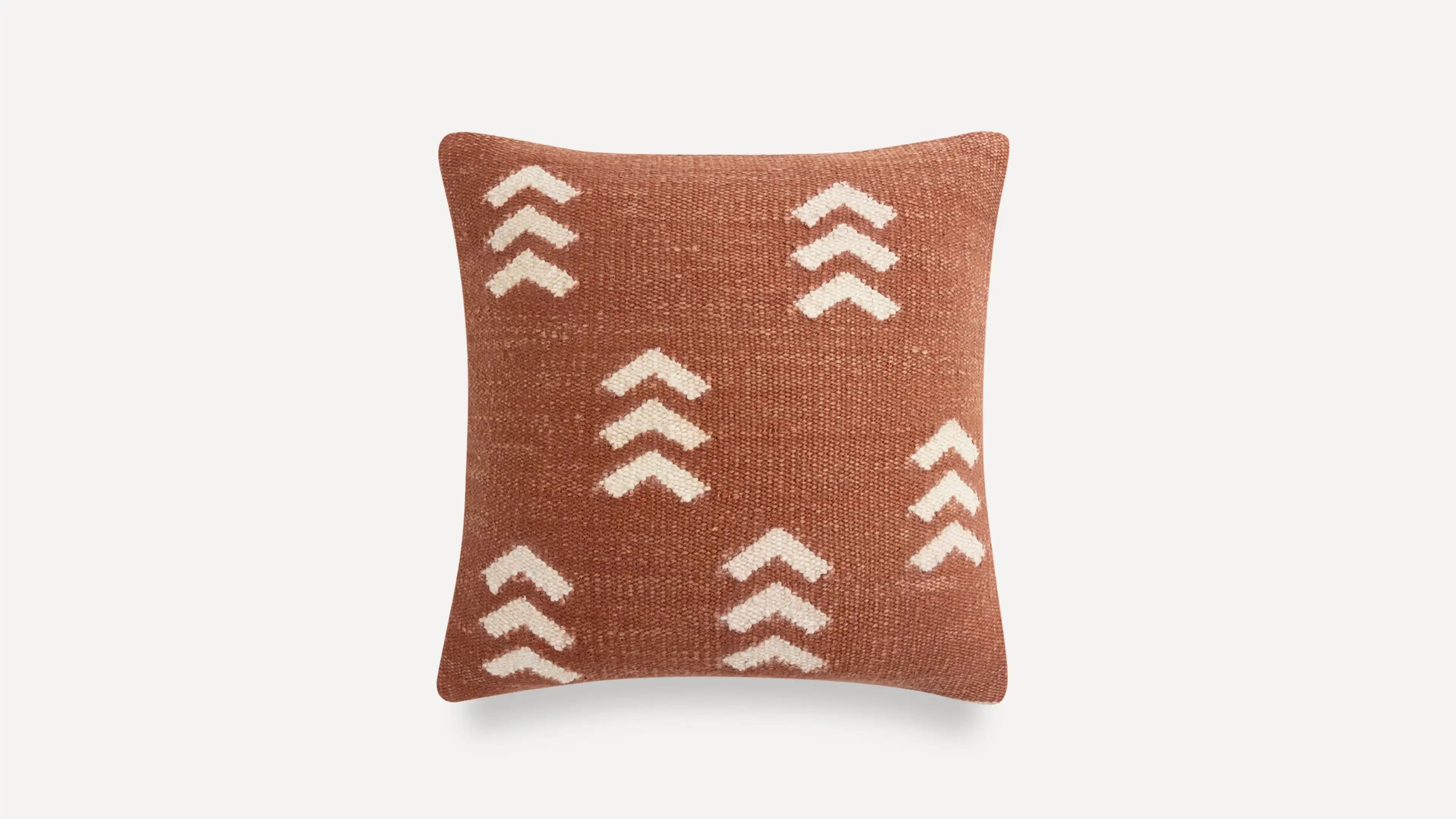 a brown and white pillow with a geometric design