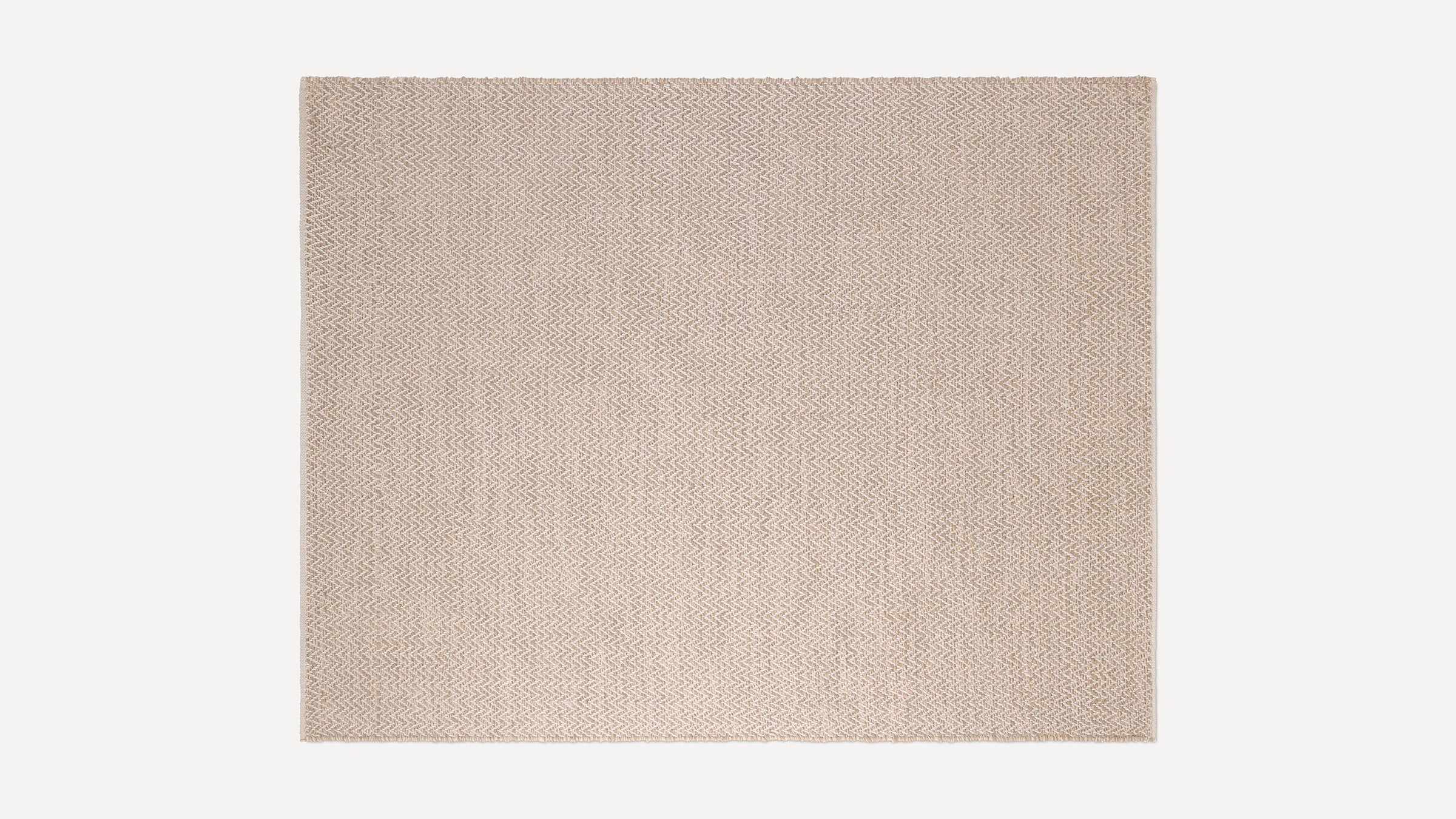 Beige woven rug with a subtle zigzag pattern in natural fiber, rectangular shape, and flat texture.