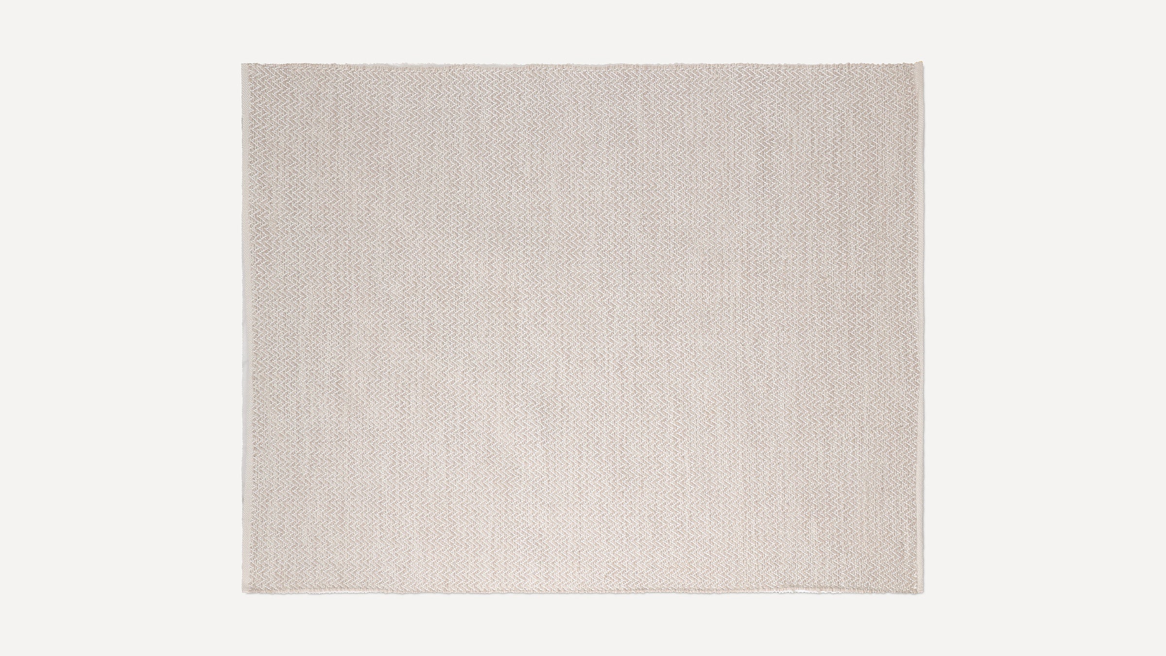 Beige woven rectangular rug with subtle chevron pattern and fringed edges, displayed on a plain white background.